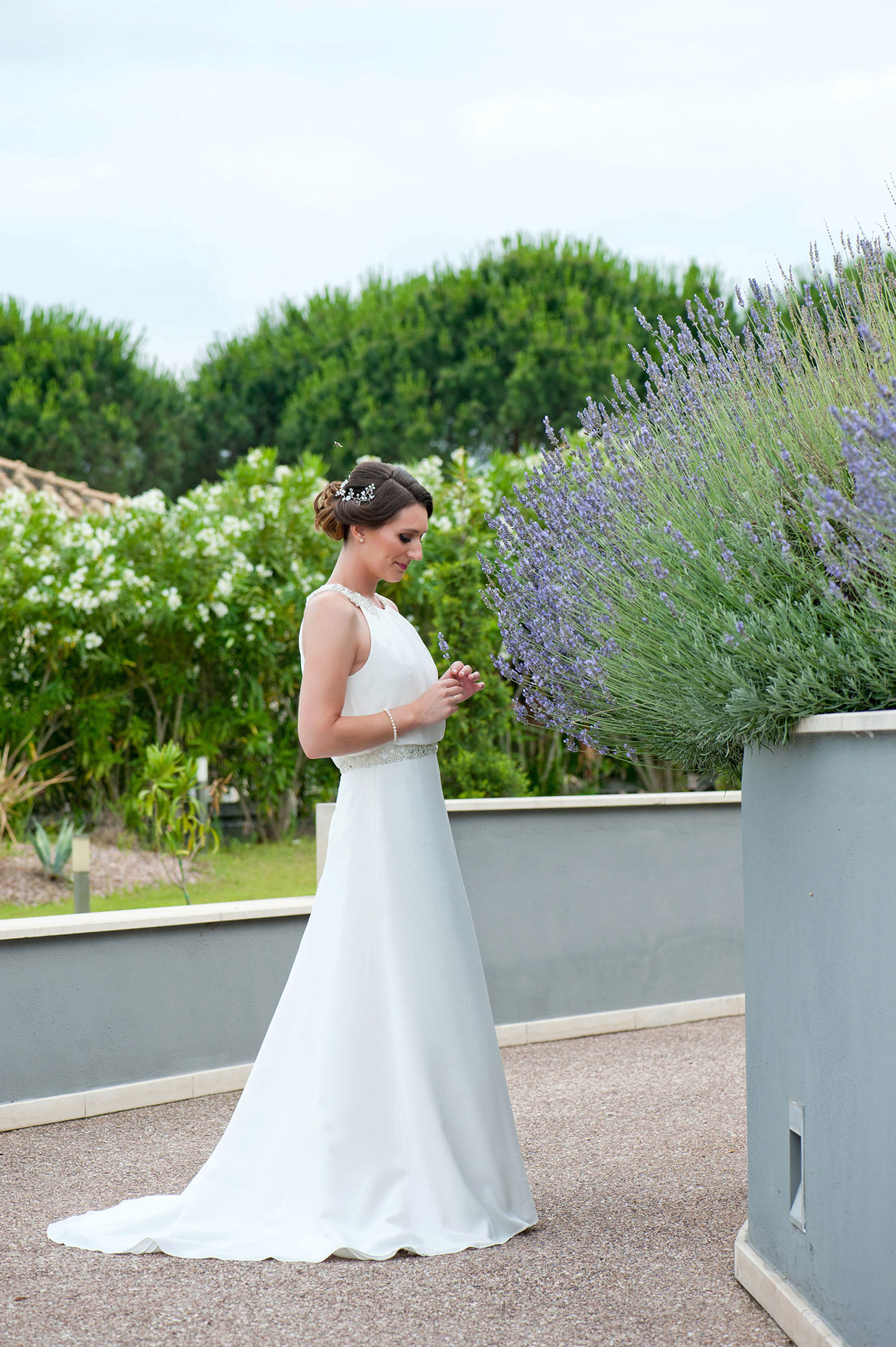 Η νύφη φωτογραφίζεται με το νυφικό της δίπλα στη λεβάντα στο Λιτόχωρο.     The bride poses in her wedding dress beside lavender in Litochoro.