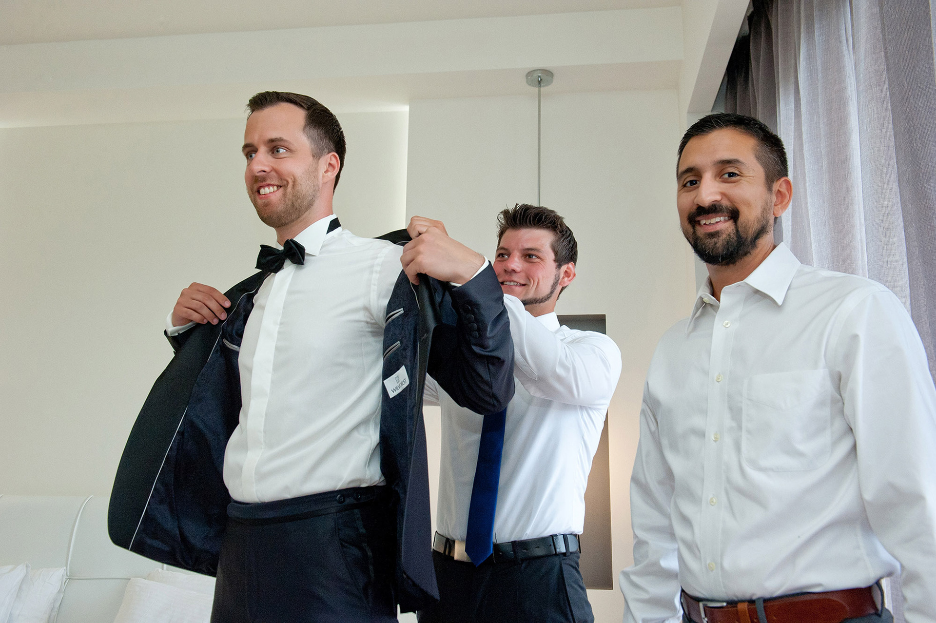 Οι φίλοι βοηθούν τον γαμπρό να φορέσει το σακάκι του πριν την τελετή στο Λιτόχωρο.     Friends helping the groom put on his jacket before the ceremony in Litochoro.