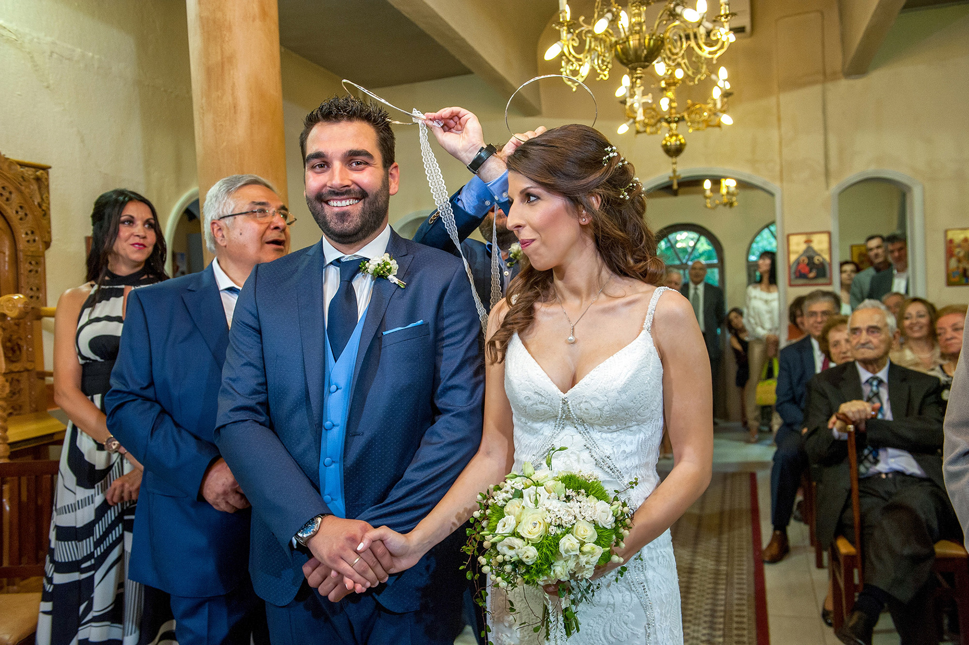 Η ιερή στιγμή του στεφανώματος στο εκκλησάκι της Αγίας Τριάδας, φωτογραφία γεμάτη συμβολισμό και συναίσθημα.     The sacred crowning moment at Agia Triada church, filled with symbolism and emotion.