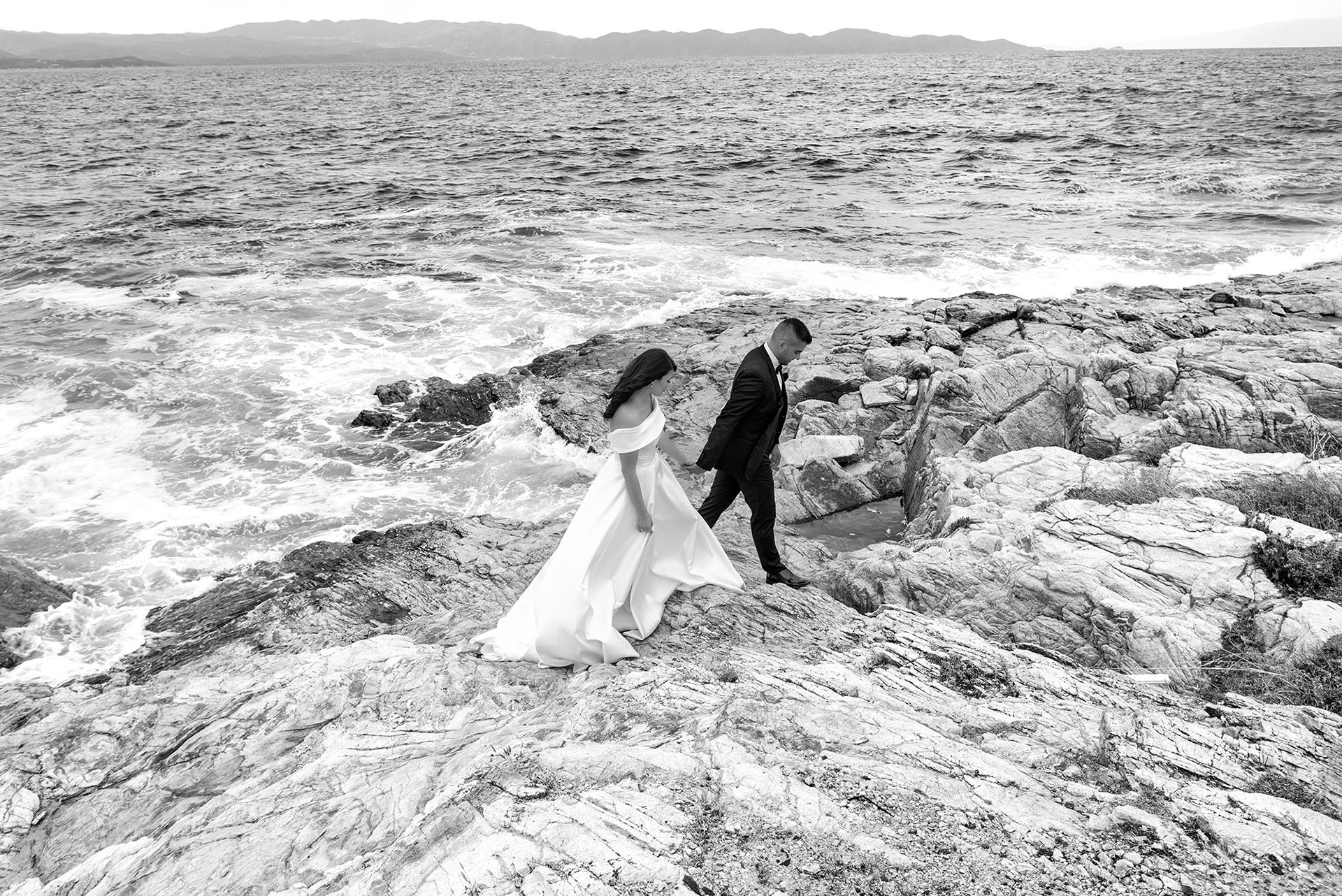 Ζευγάρι στη φωτογράφιση γάμου με κύμα που σκάει στα βράχια, Couple wedding photoshoot with waves crashing on the rocks