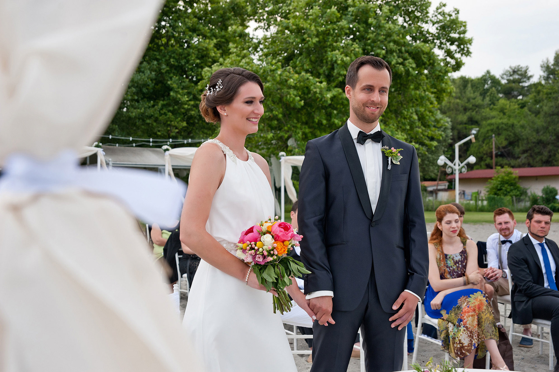 Η νύφη και ο γαμπρός κρατιούνται χέρι χέρι στην τελετή γάμου στο Λιτόχωρο.  The bride and groom holding hands during their wedding ceremony in Litochoro.