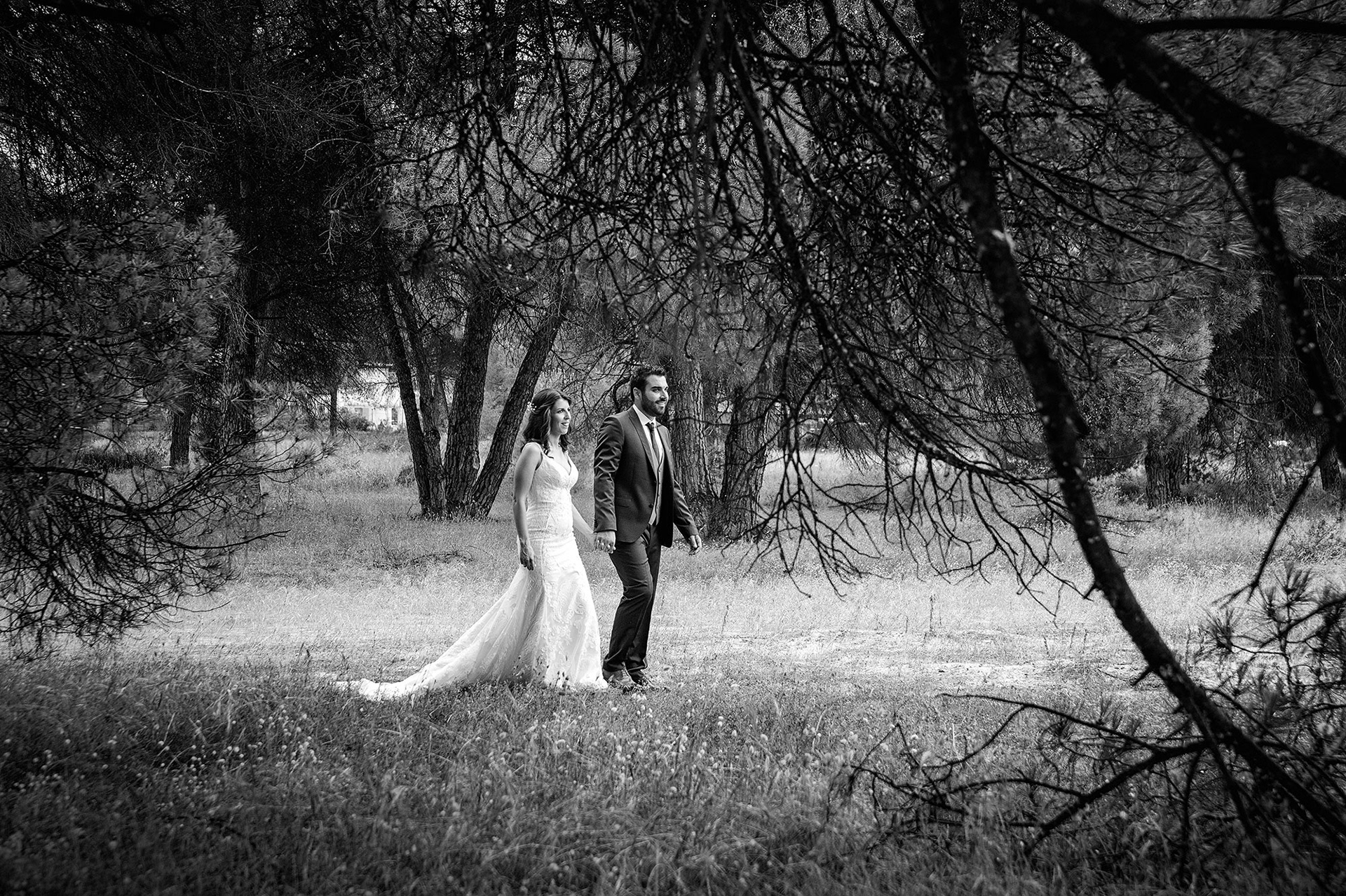 Ο γαμπρός και η νύφη περπατούν πιασμένοι χέρι-χέρι στο δάσος κατά τη φωτογράφιση μετά τον γάμο.   The bride and groom walking hand in hand through the forest during their next day photoshoot.