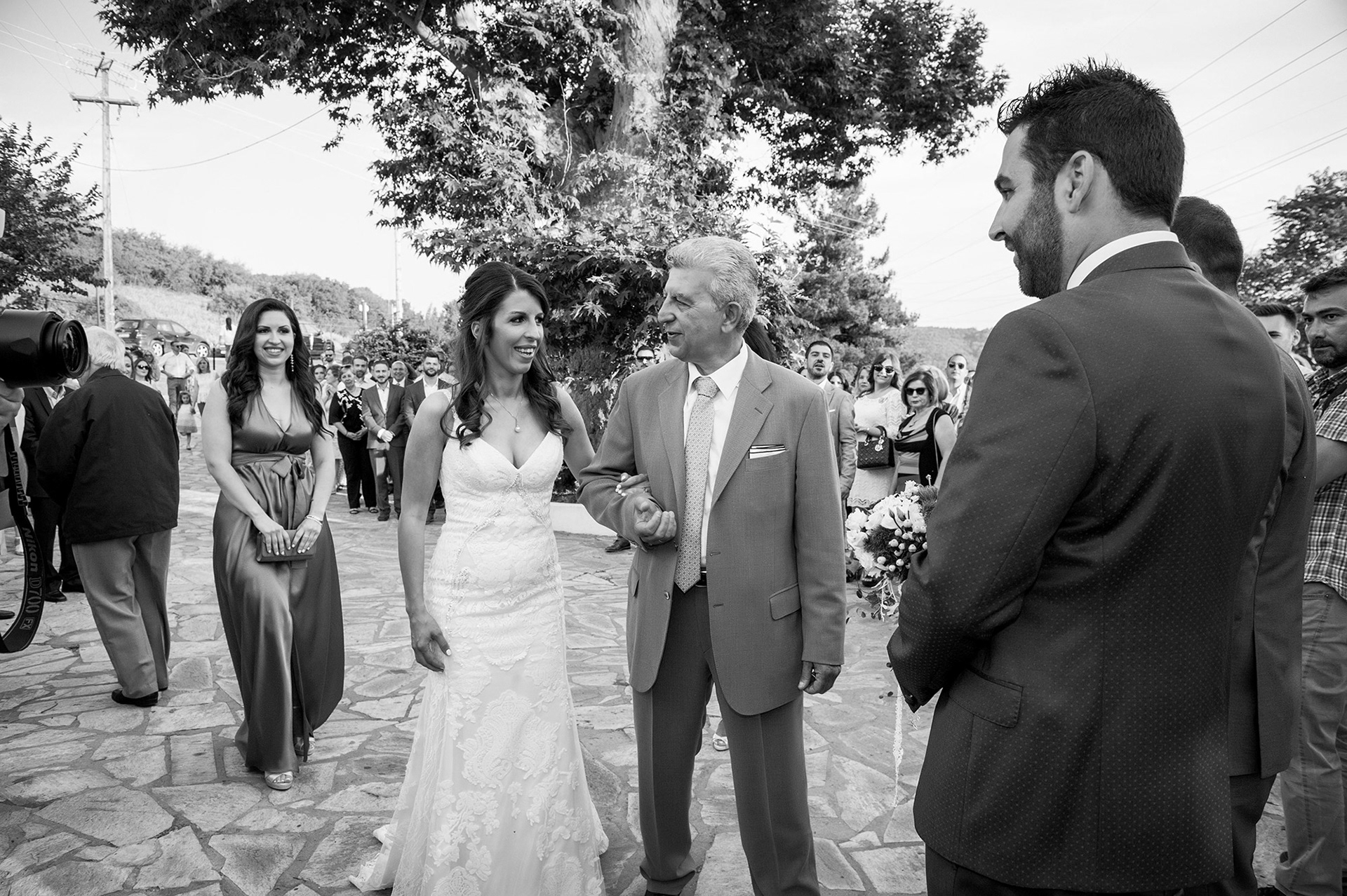 Η νύφη φτάνει μπροστά στην εκκλησία και συναντά τον γαμπρό, σε μια συγκινητική στιγμή λίγο πριν τον γάμο.     The bride reaches the church entrance and meets the groom, a touching moment just before the wedding ceremony.