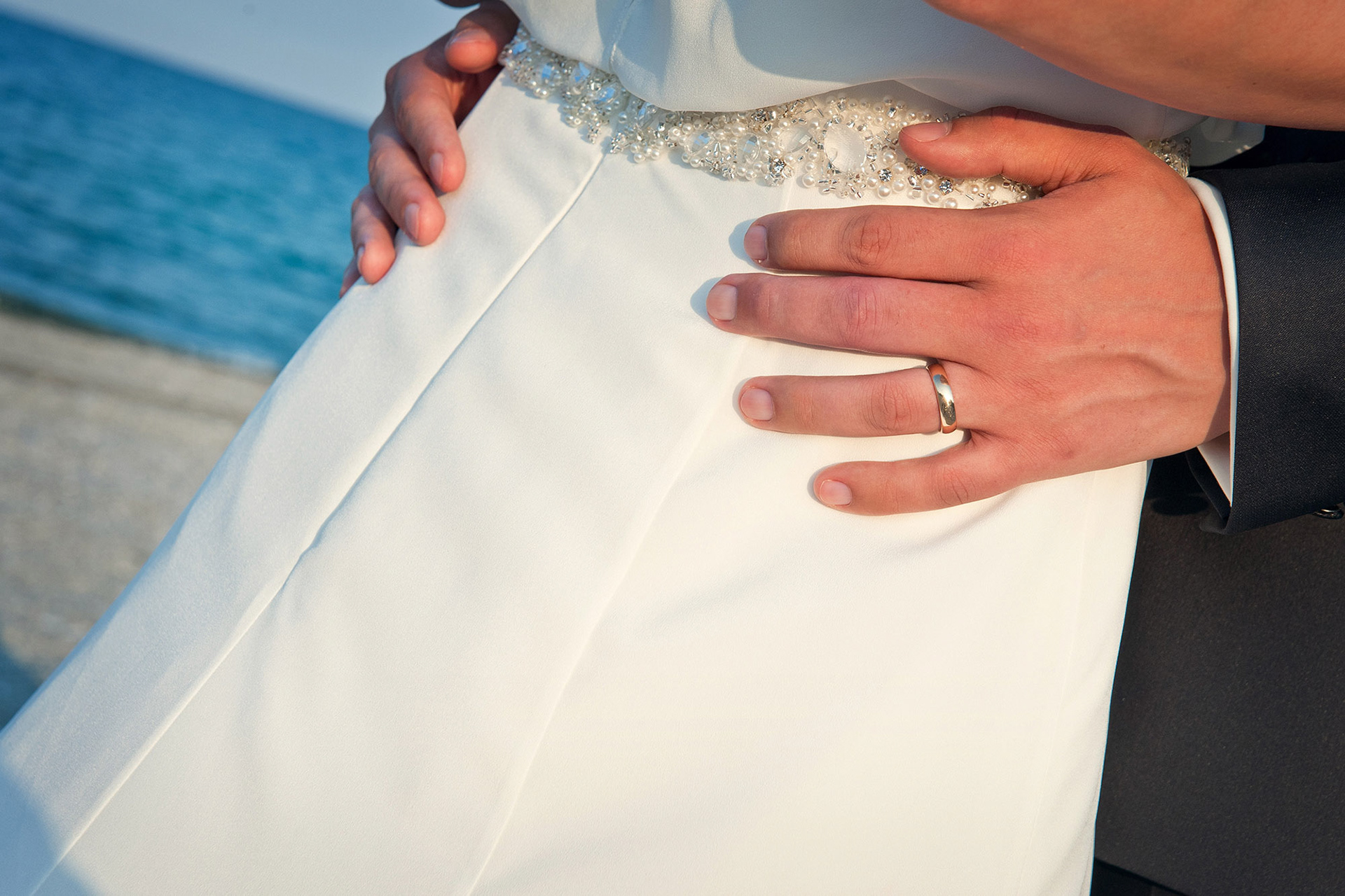 Κοντινό πλάνο στα χέρια του ζευγαριού που δείχνει τις βέρες του γάμου.   Close-up of the couple’s hands showing their wedding rings.