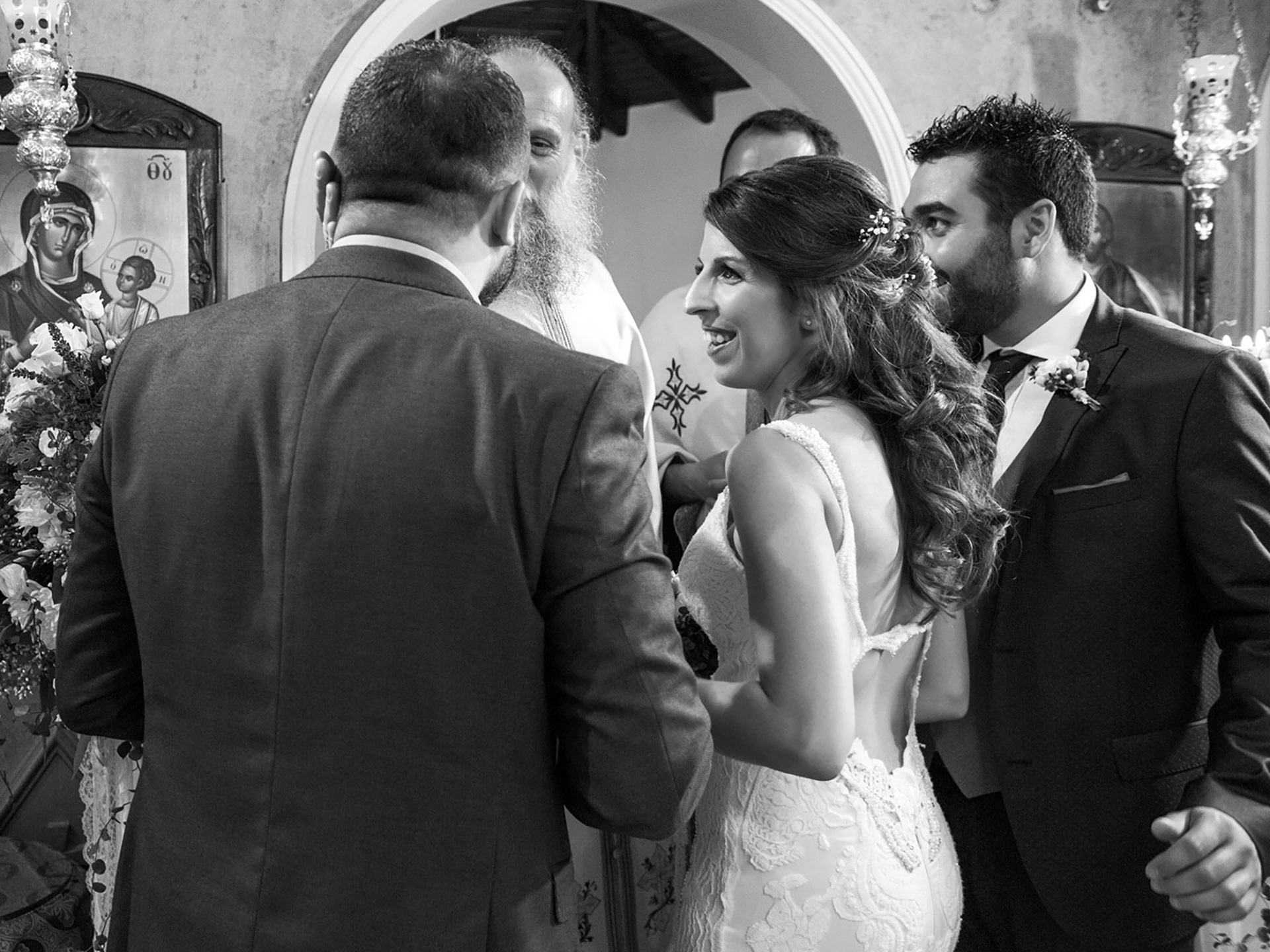 Η νύφη και ο γαμπρός χαμογελούν συγκινημένοι κατά τη διάρκεια της στέψης μέσα στην εκκλησία.     The bride and groom smile emotionally during the crowning part of their Orthodox wedding inside the church.