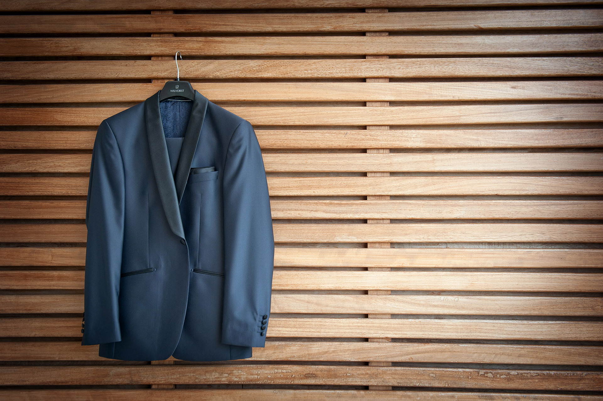 Το κοστούμι του γαμπρού κρεμασμένο σε ξύλινο φόντο στο Litoxoro resort and spa ,        The groom’s suit hanging on a wooden wall in Litochoro  resort and spa