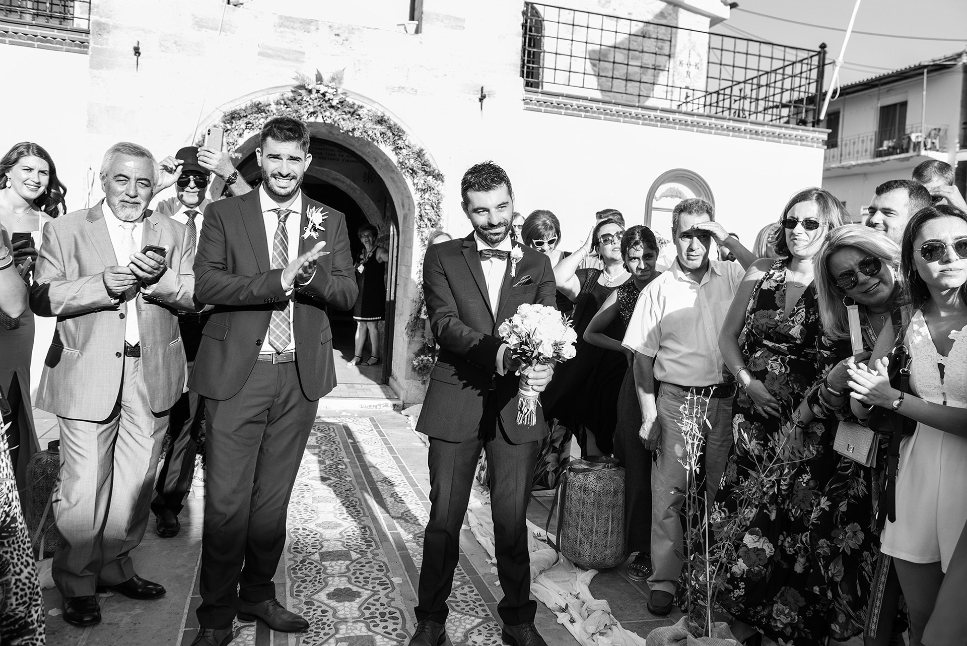 γαμπρός και ο κουμπάρος βλέπουν τη νύφη να έρχεται συνοδευόμενη από τον πατέρα της - φωτογράφιση γάμου χαλκιδική, groom and best man see the bride arriving accompanied by her father - wedding photography chalkidiki