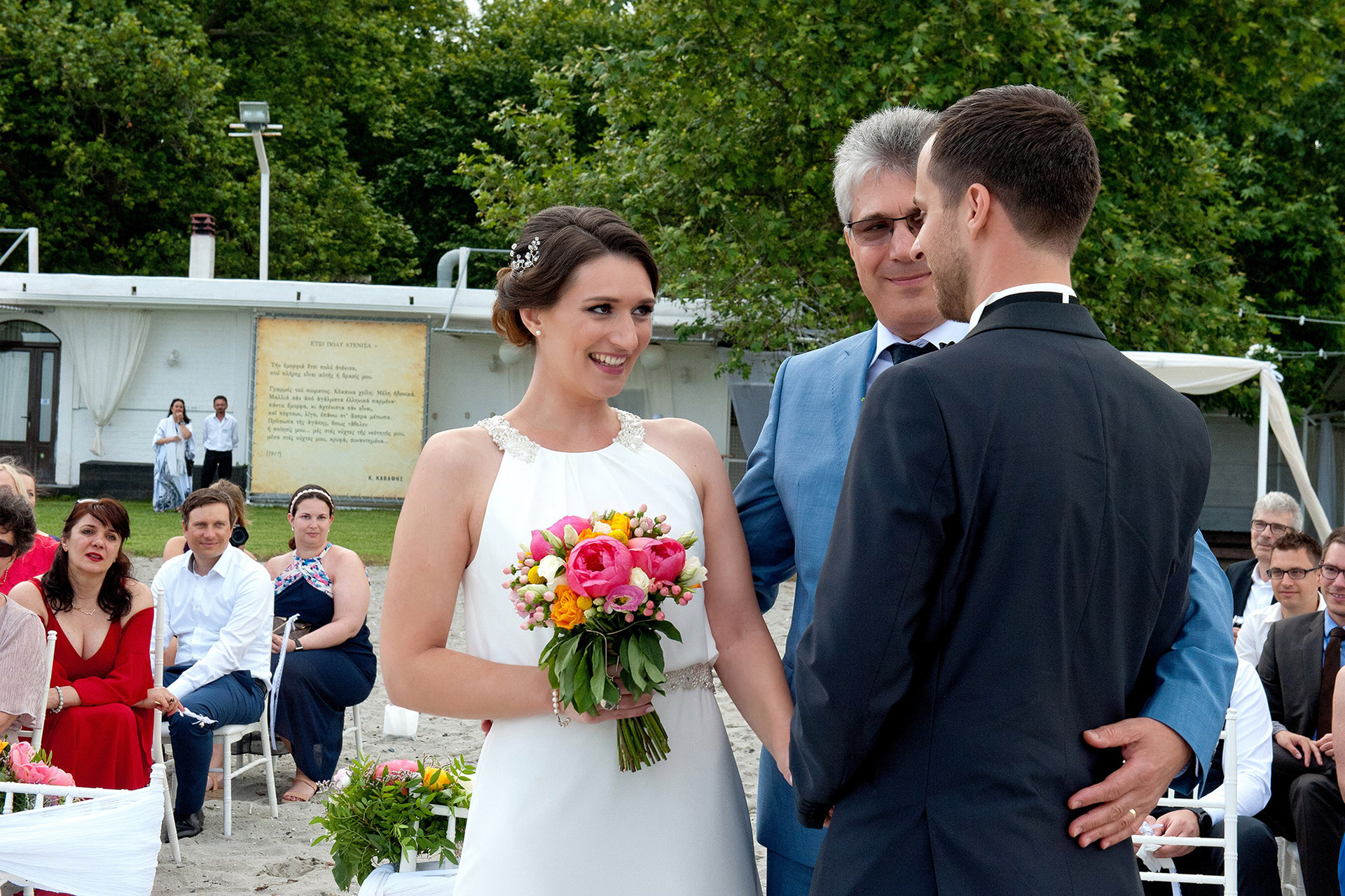 Η νύφη συναντά τον γαμπρό μπροστά στους καλεσμένους στην τελετή του γάμου στην παραλία.  The bride meets the groom in front of their guests at the beach wedding ceremony.