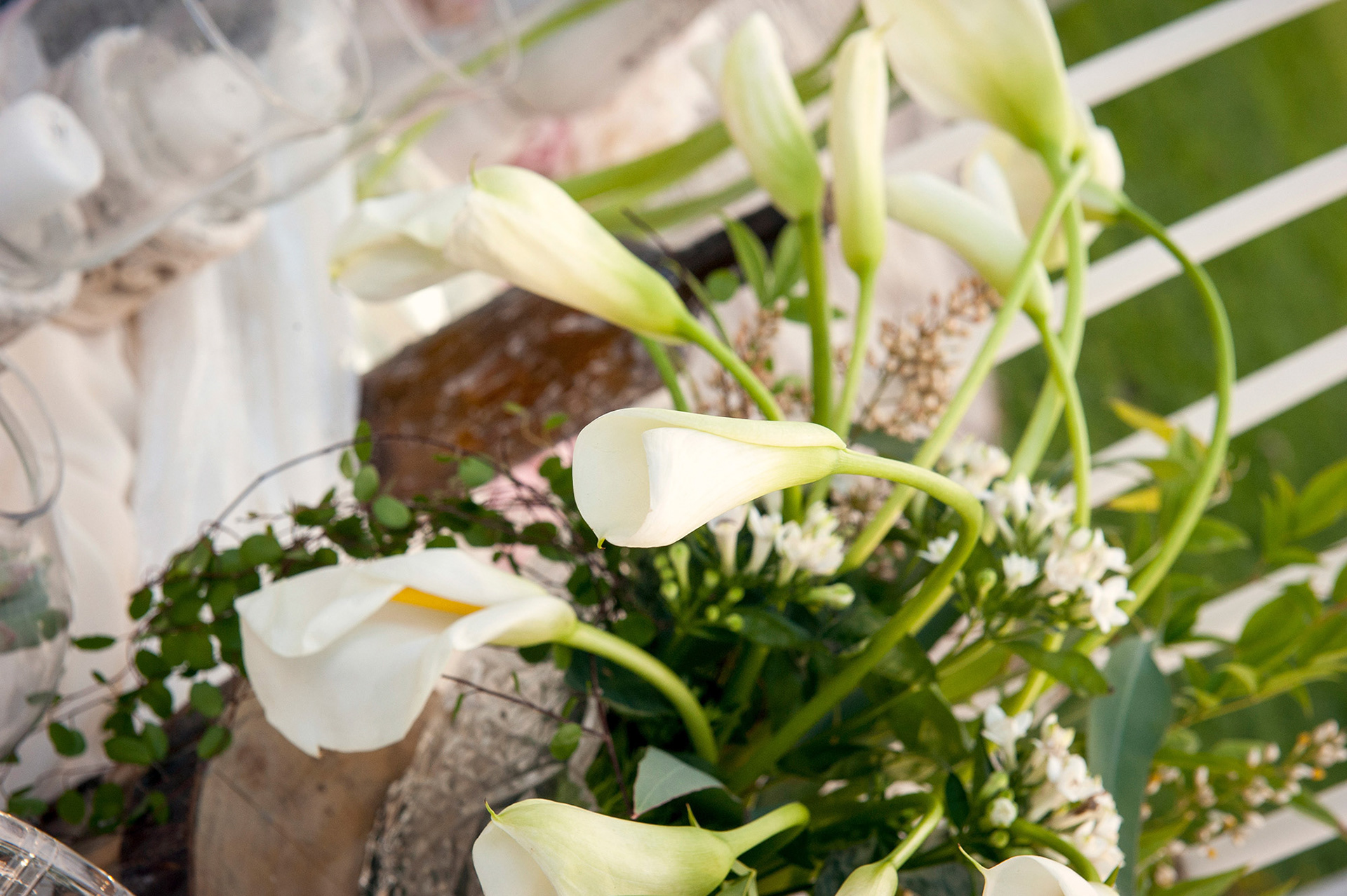 Λεπτομέρεια με λευκές καλλίες και πράσινα φύλλα σε ρομαντική ανθοδέσμη γάμου.    Detail of white calla lilies and green leaves in a romantic wedding bouquet.