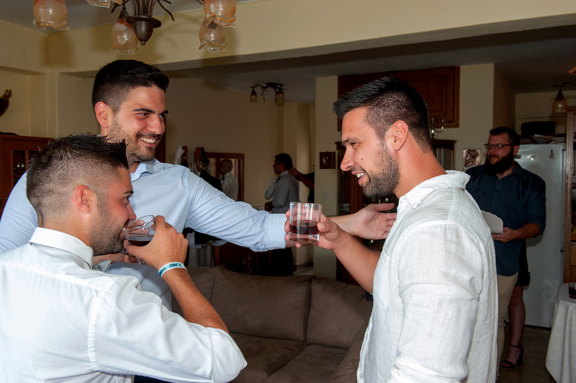 γαμπρός με φίλους στο σπίτι του πίνουν και συζητούν στη διάρκεια της προετοιμασίας του για τη φωτογράφιση γάμου στα πυργαδίκια χαλκιδικής,    Groom with friends at his house drinking and chatting during his preparation for the wedding photography in Pyrgadikia, Halkidiki