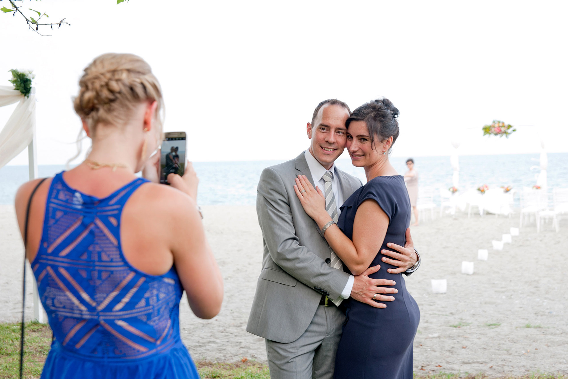 Καλεσμένοι φωτογραφίζονται στην παραλία του γάμου λίγο πριν ξεκινήσει η τελετή.     Guests posing for a photo on the beach wedding setup before the ceremony begins.