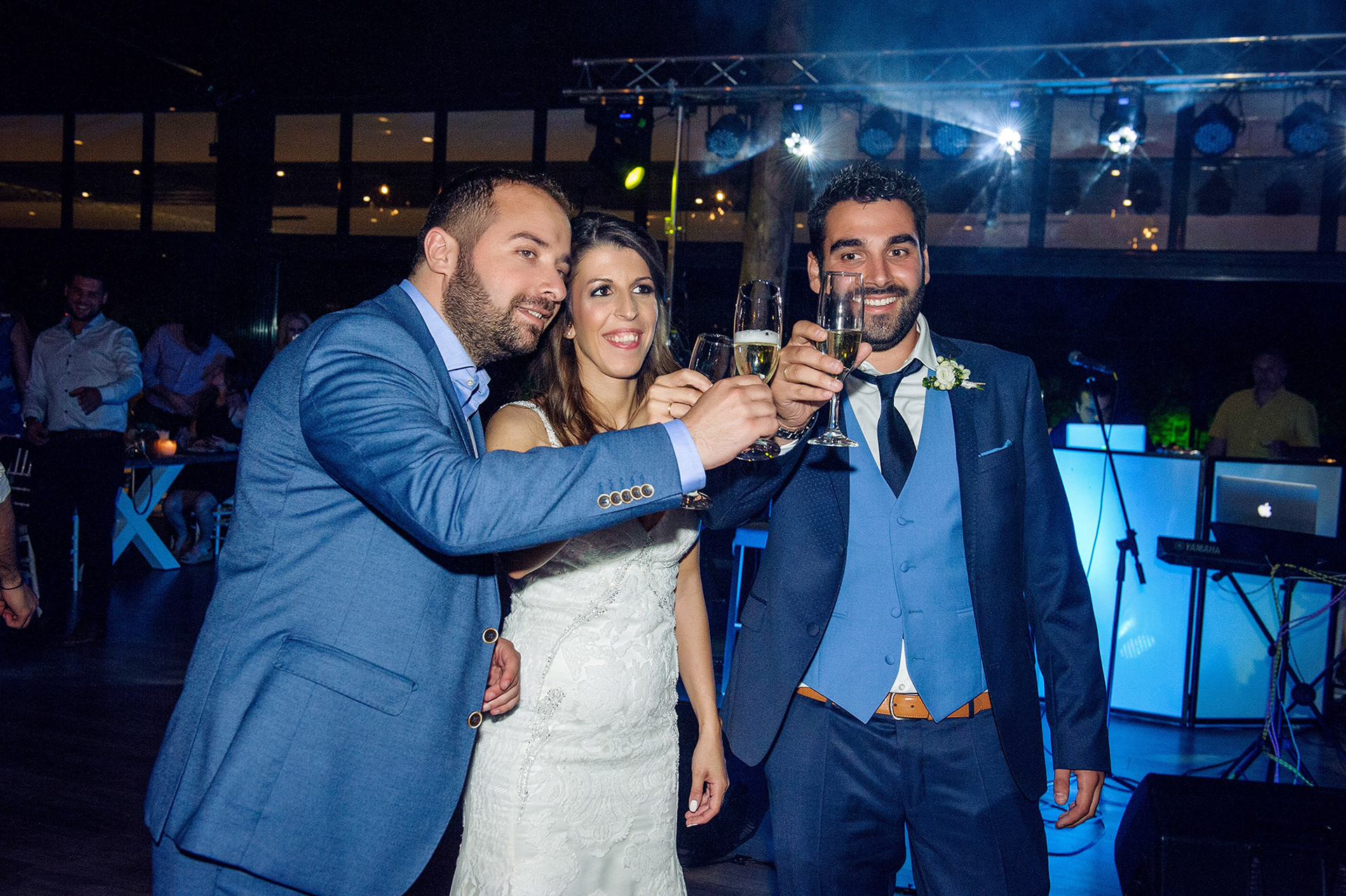 Η νύφη και ο γαμπρός κάνουν πρόποση με σαμπάνια μαζί με φίλους στη δεξίωση του γάμου.    The bride and groom make a champagne toast with friends during the wedding reception.