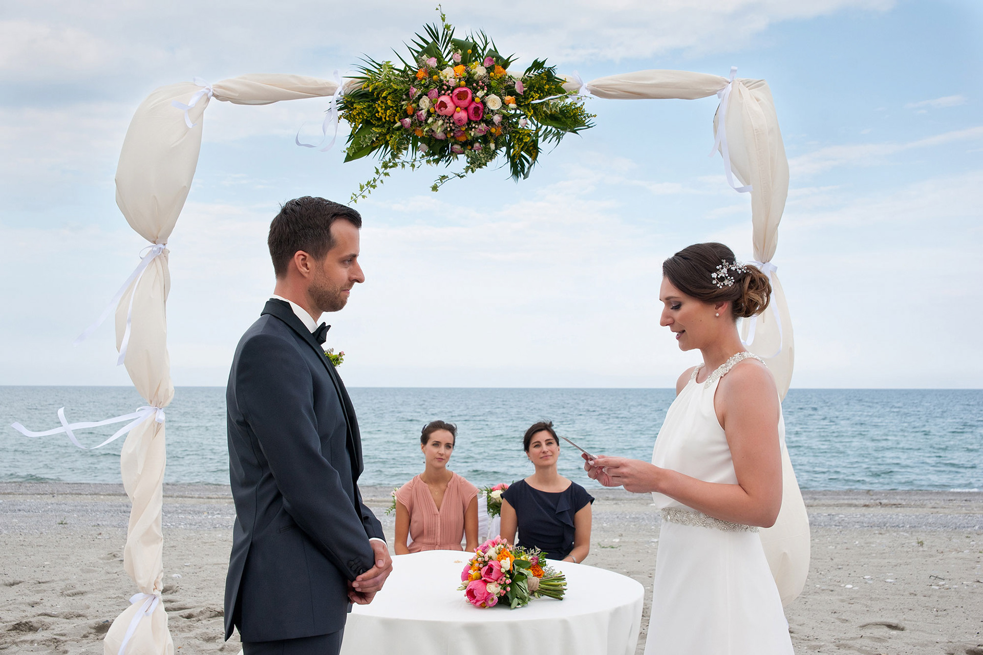 Η νύφη διαβάζει με συγκίνηση τους όρκους αγάπης της μπροστά στον γαμπρό.   The bride reading her heartfelt vows to the groom during the ceremony.