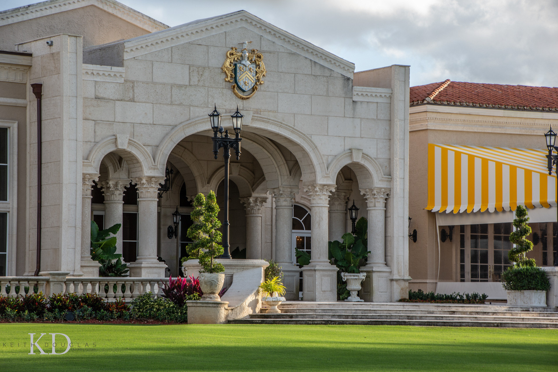 Exterior view of luxury golf clubhouse in South Florida with palm trees and ambient lighting