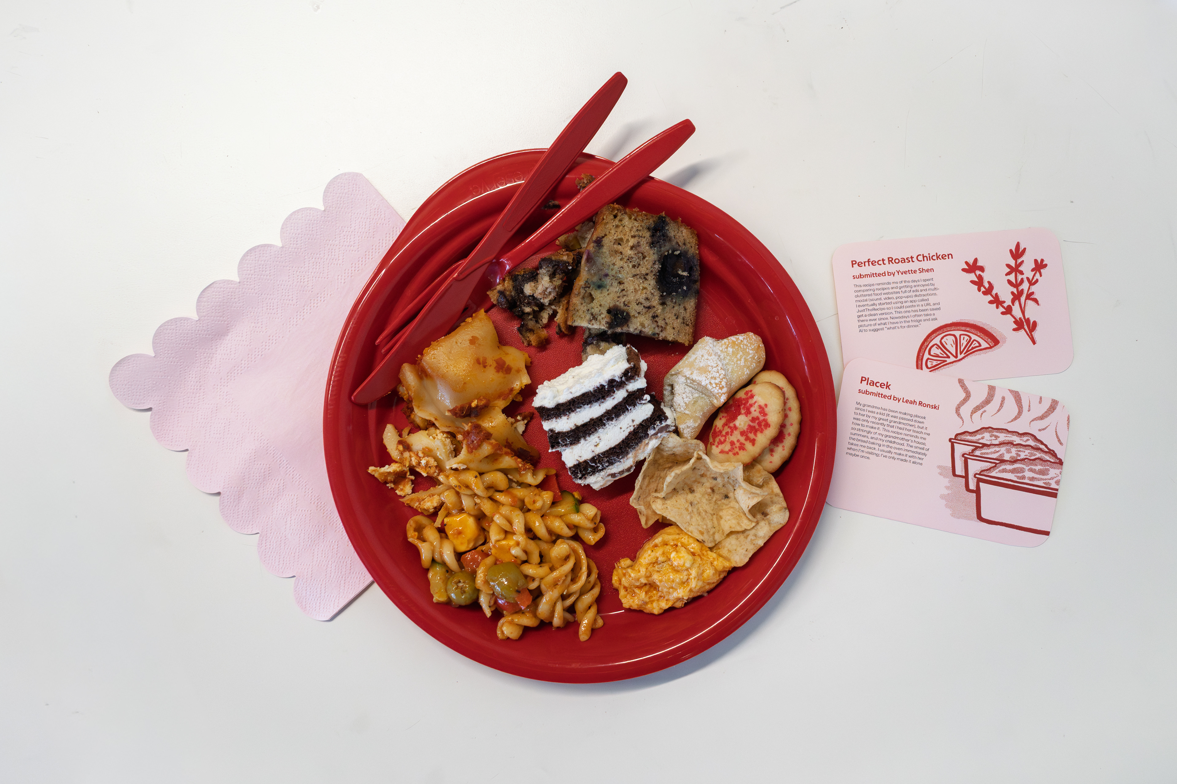 Plate of potluck event food next to recipe cards.