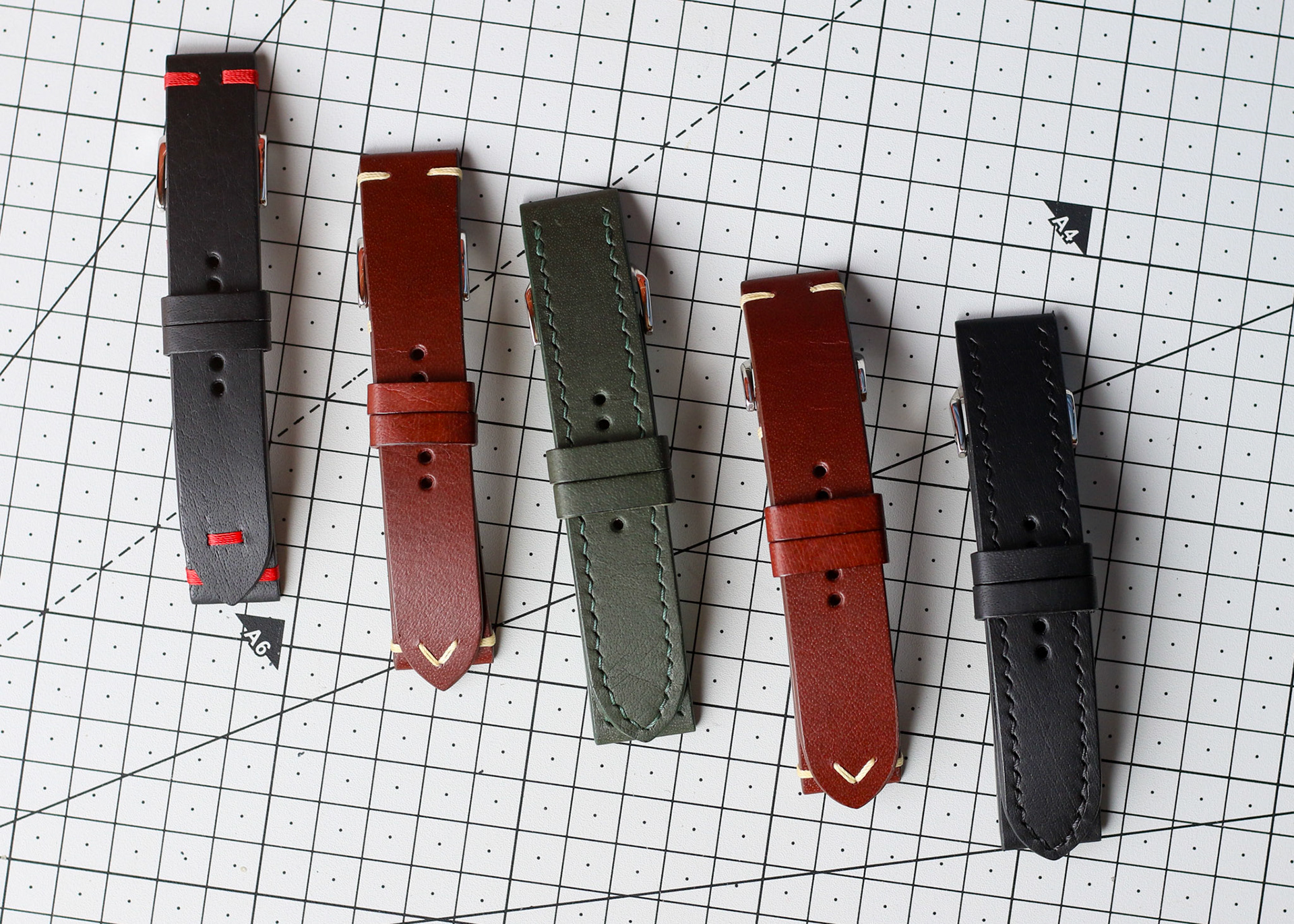 collection of handmade leather watch straps in different colours arranged side by side