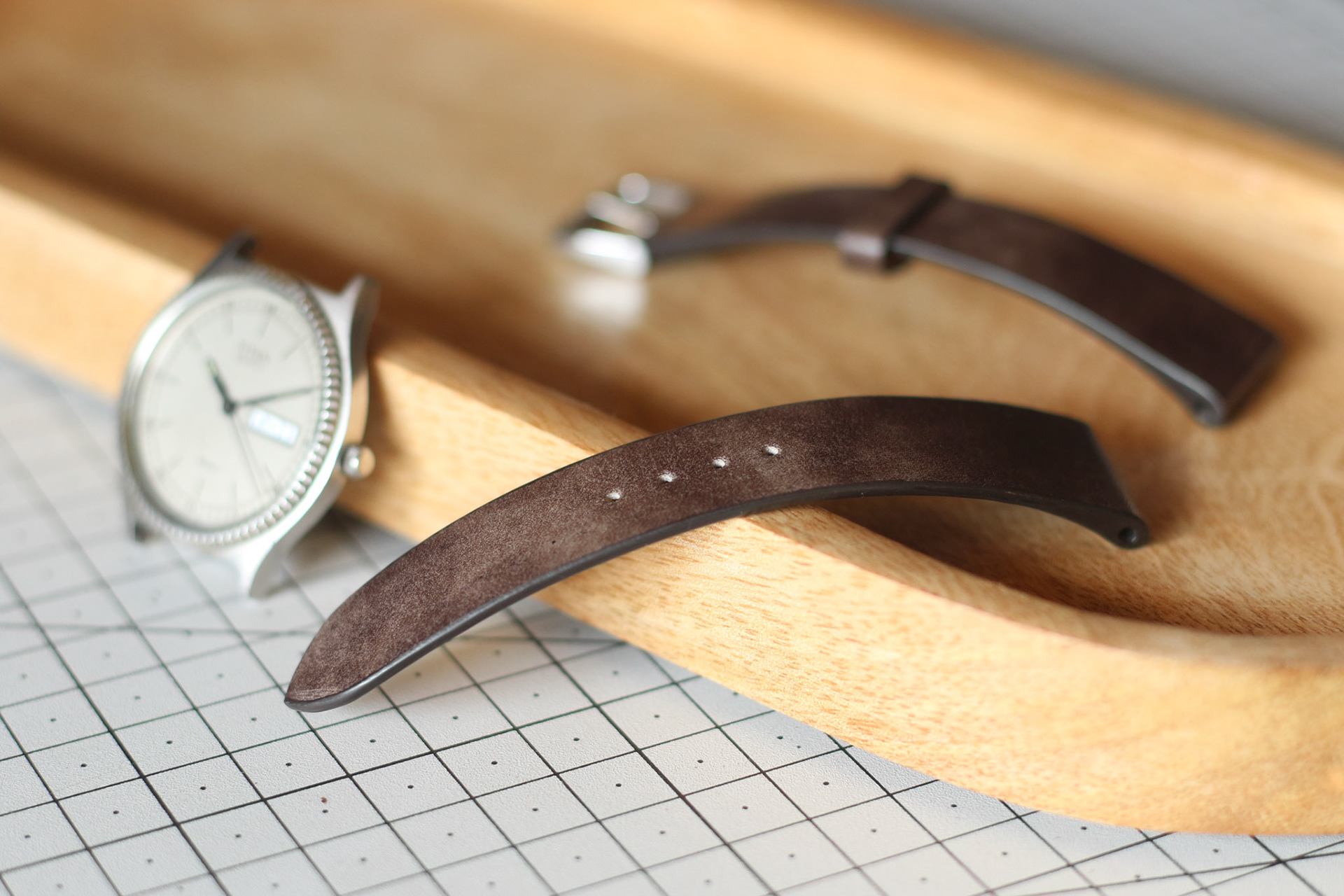 close-up of a handcrafted leather watch strap showing rich patina