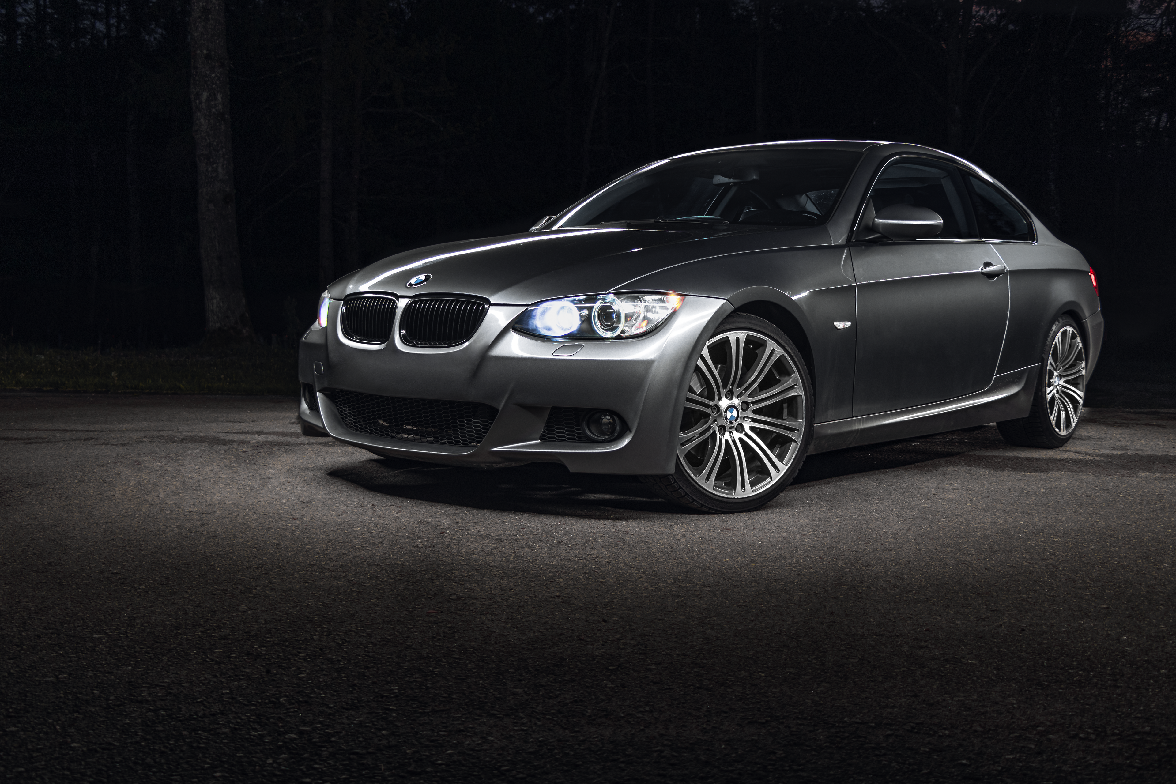 A Silver BMW E92 328i light painting in a dark forest car/automotive photography