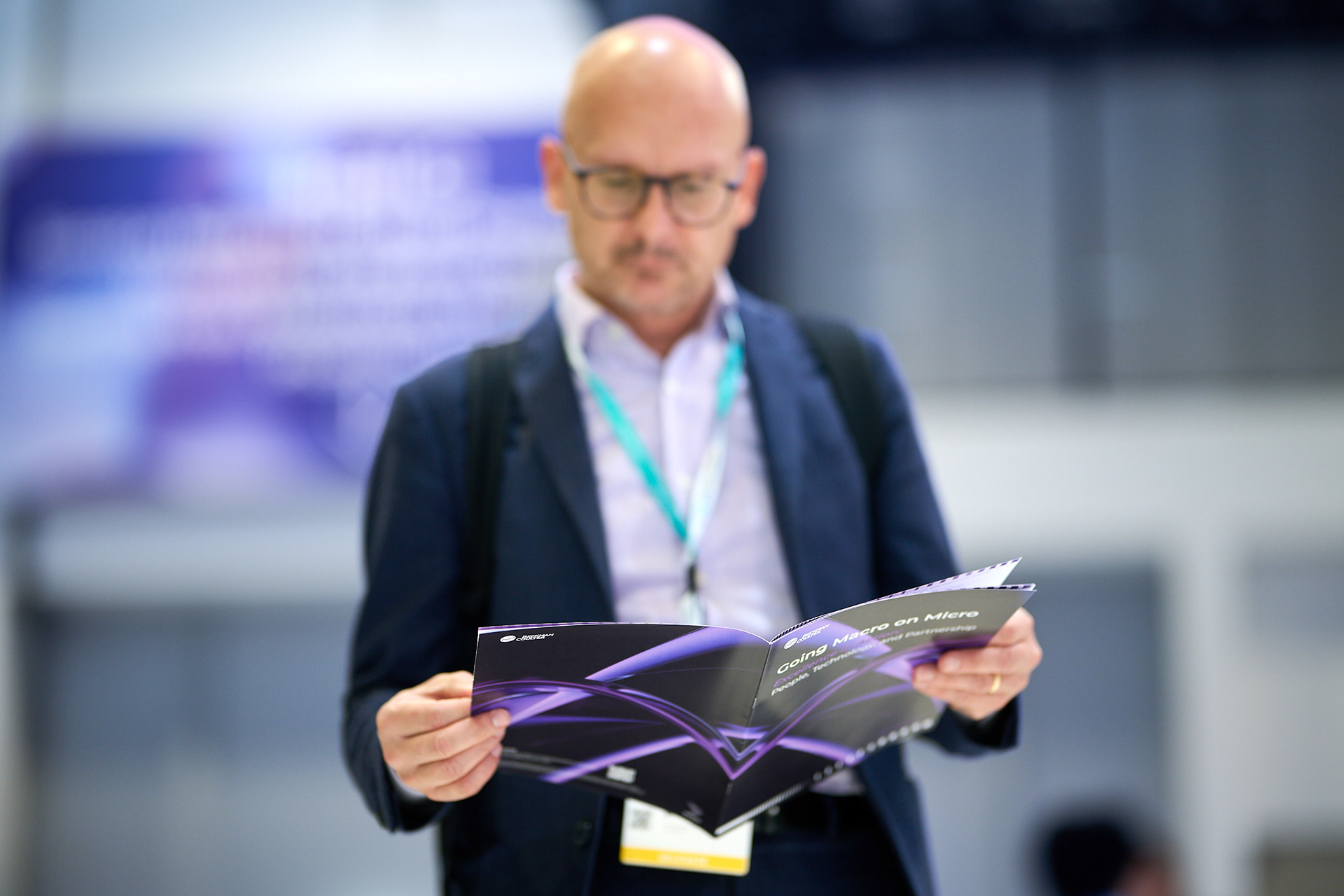Attendee reading brochures at a congress exhibition
