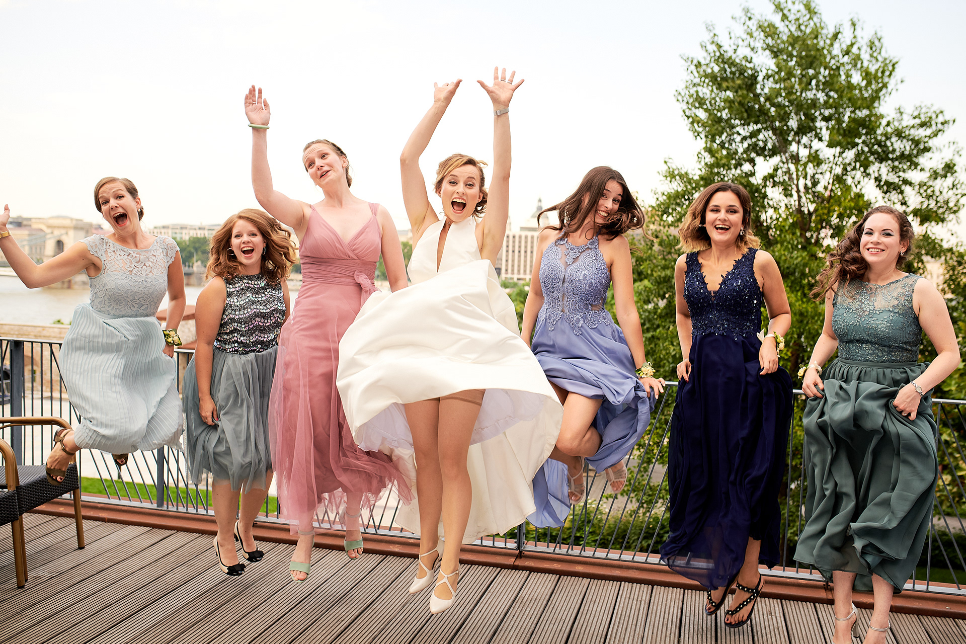 Ladies are jumping on a wedding group photo.