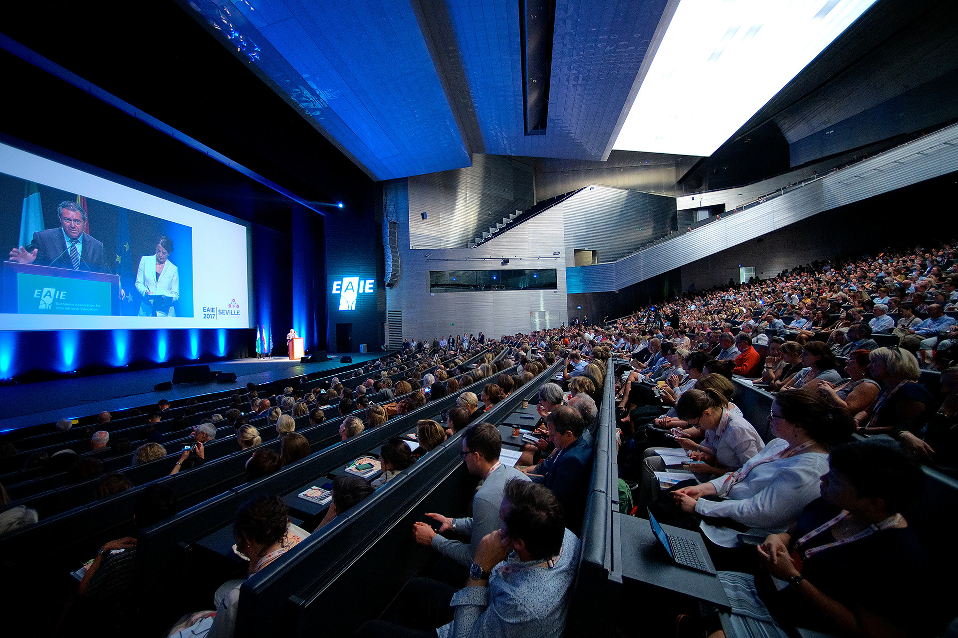 peaker presenting to a large conference audience in Geneva