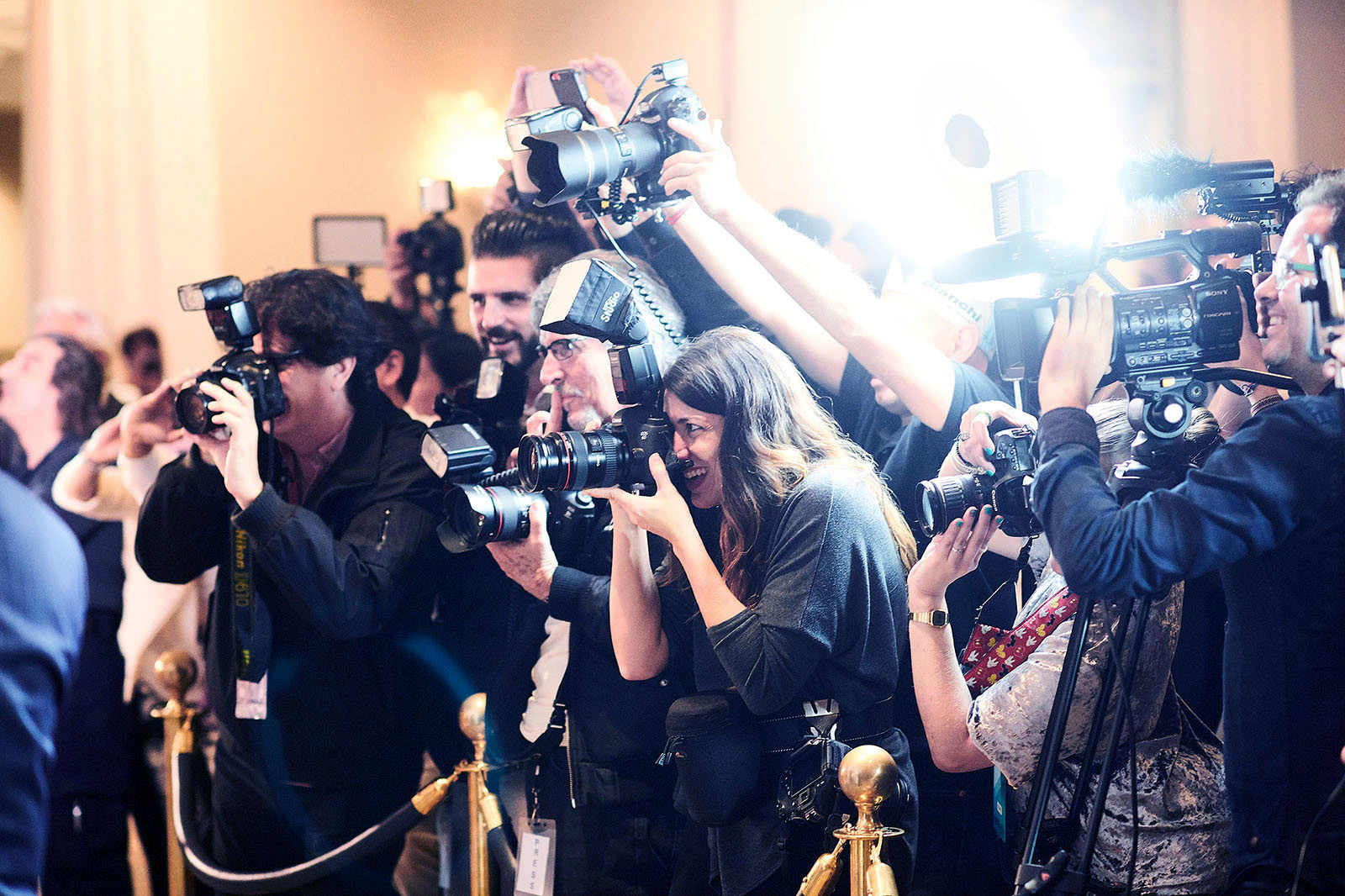 Photographers and videographers covering a press conference.