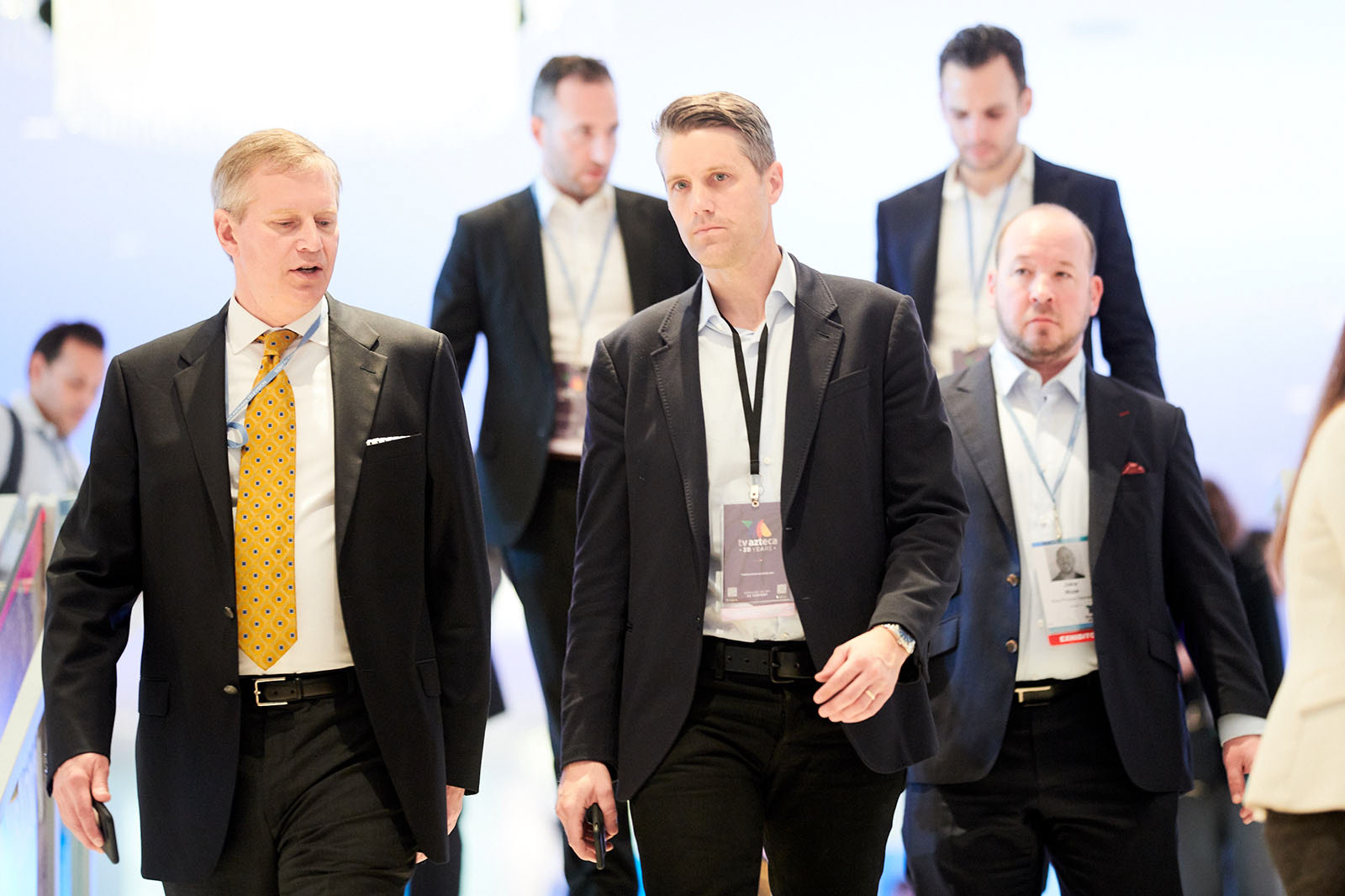 Dynamic image of participants dressed in suits.