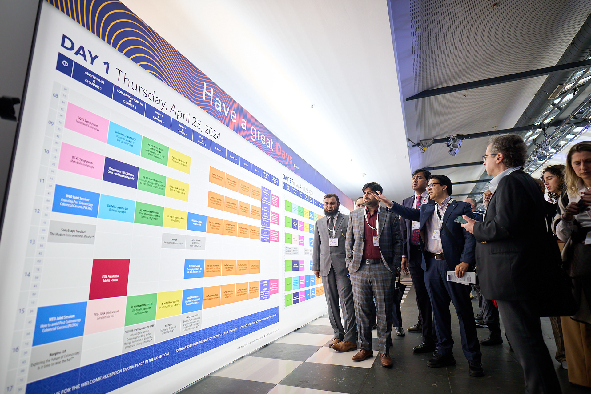 Attendees checking the conference schedule.