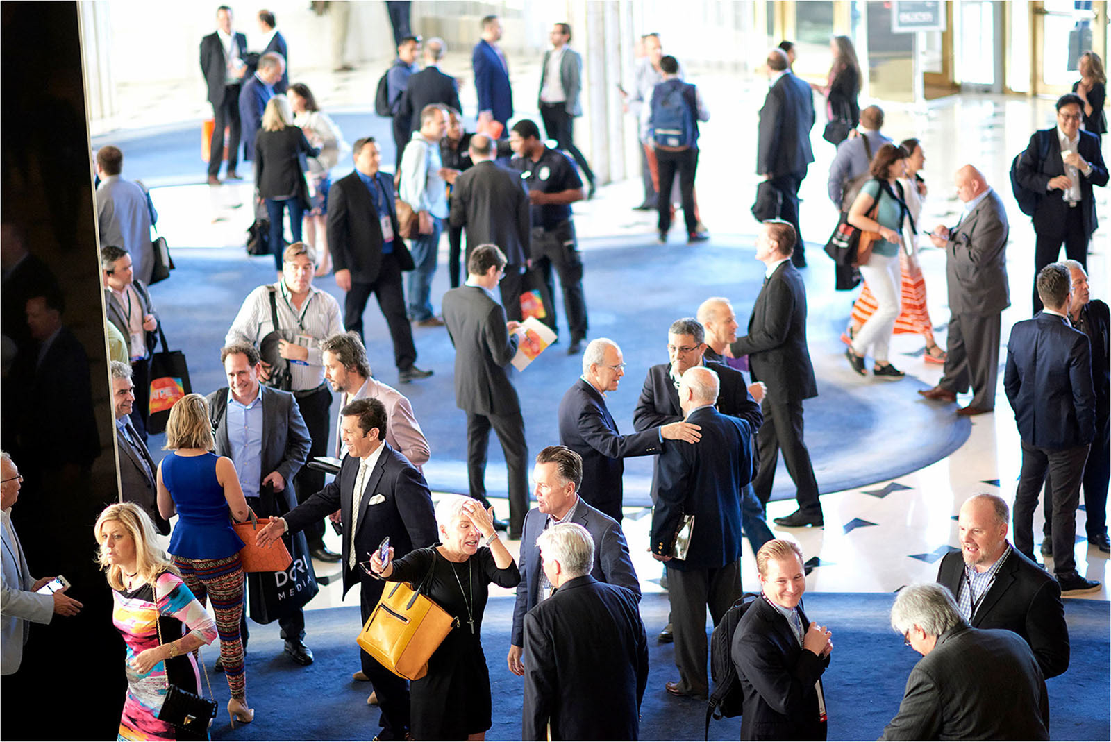 Crowded hall filled with businessmen networking.