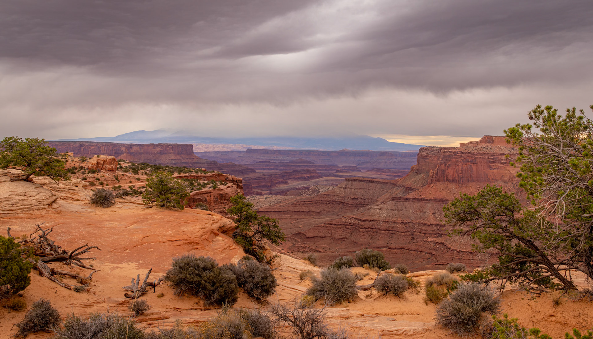 Shafer Canyon Overlook - Moody cloud cover blanketing the La Sal Mountains in the background