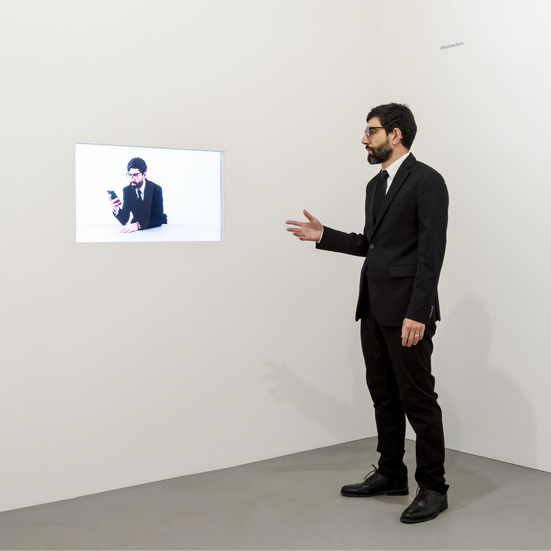 photo of David Cuesta the artist staring at a video of David Cuesta the artist staring at a phone for 1 hour.