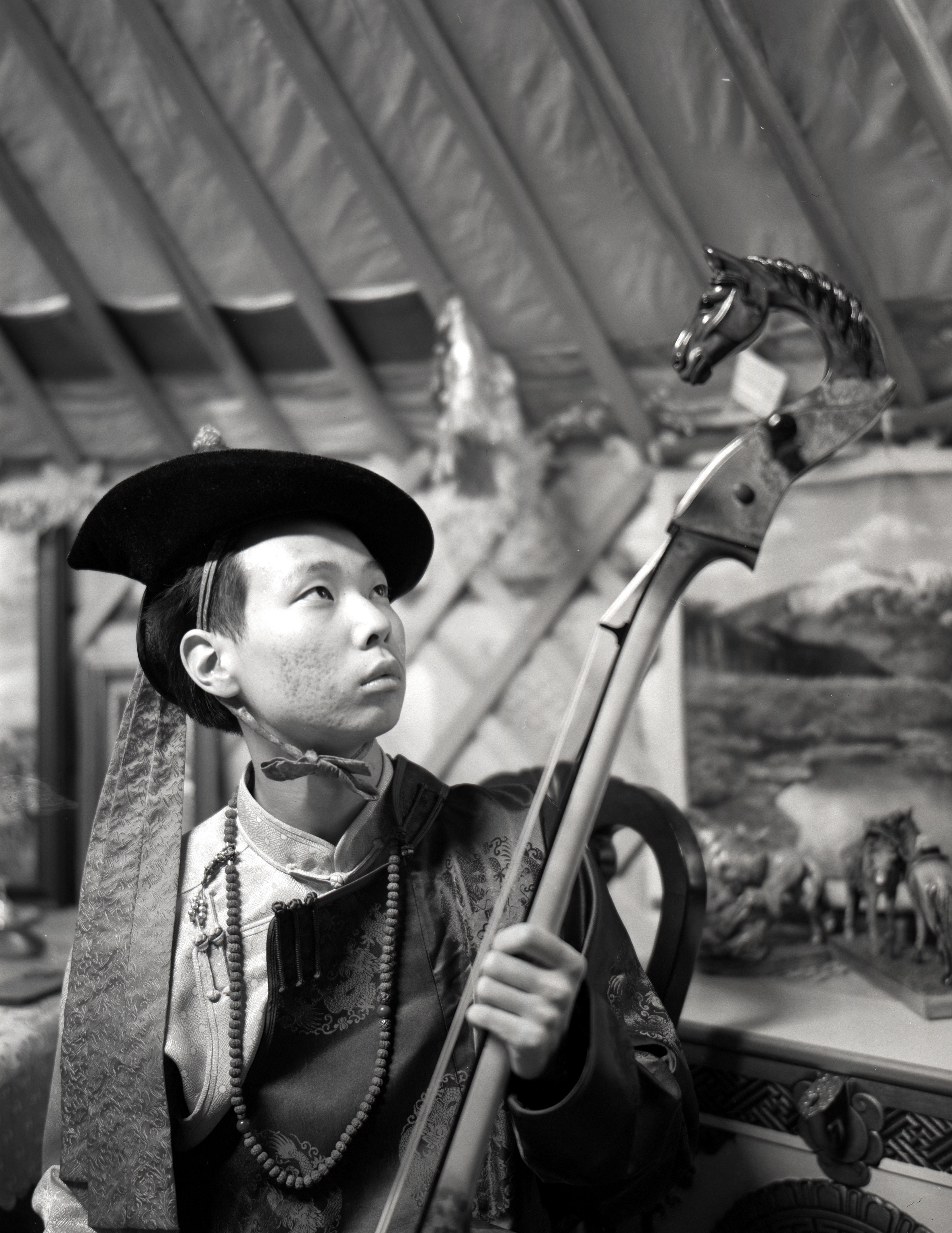 A portrait of my brother holding a traditional Mongolian instrument, the morin khuur.
