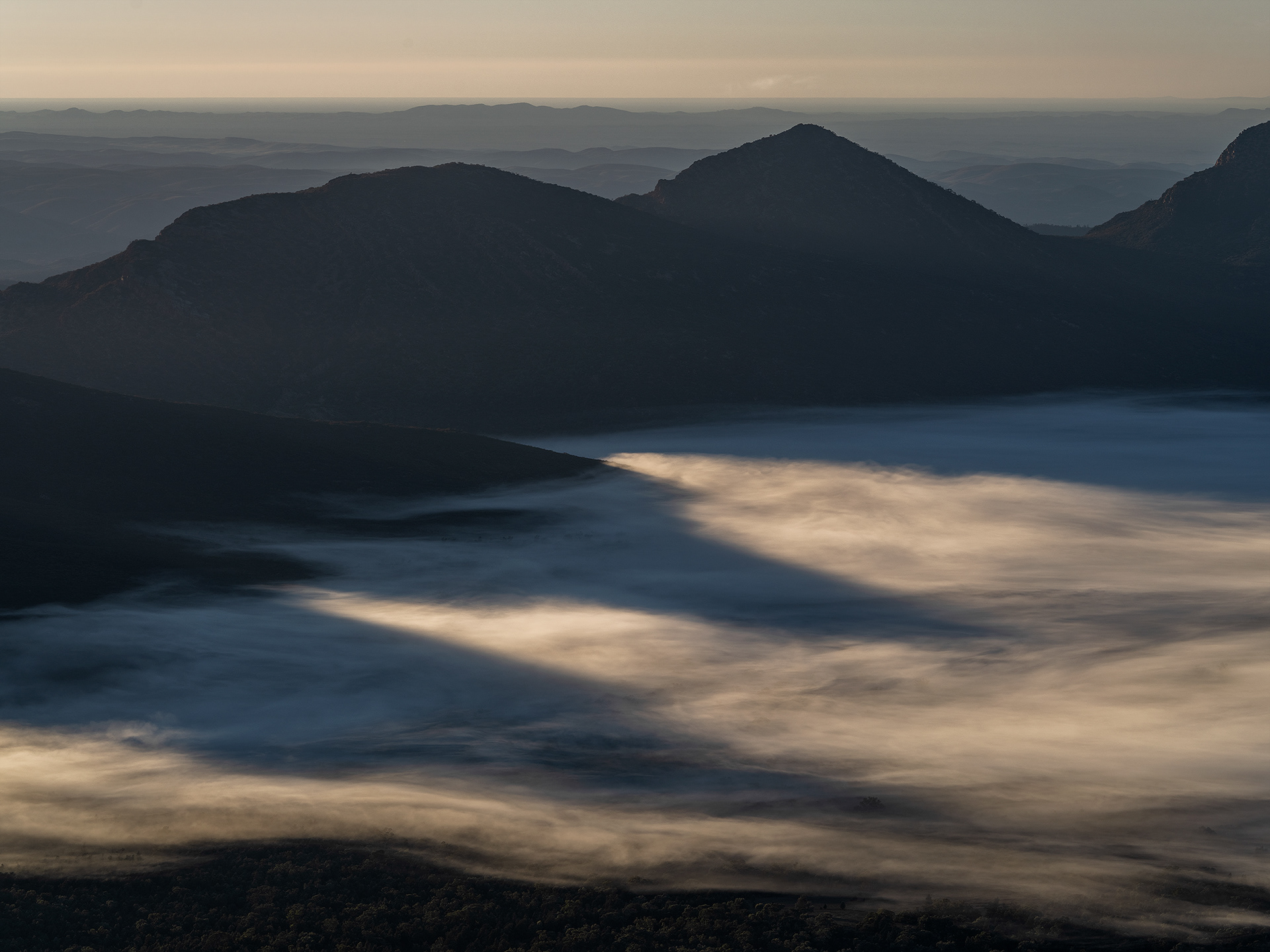 Peaks of Ikara Wilpena Pound cast vast shadows onto the foggy pound floor