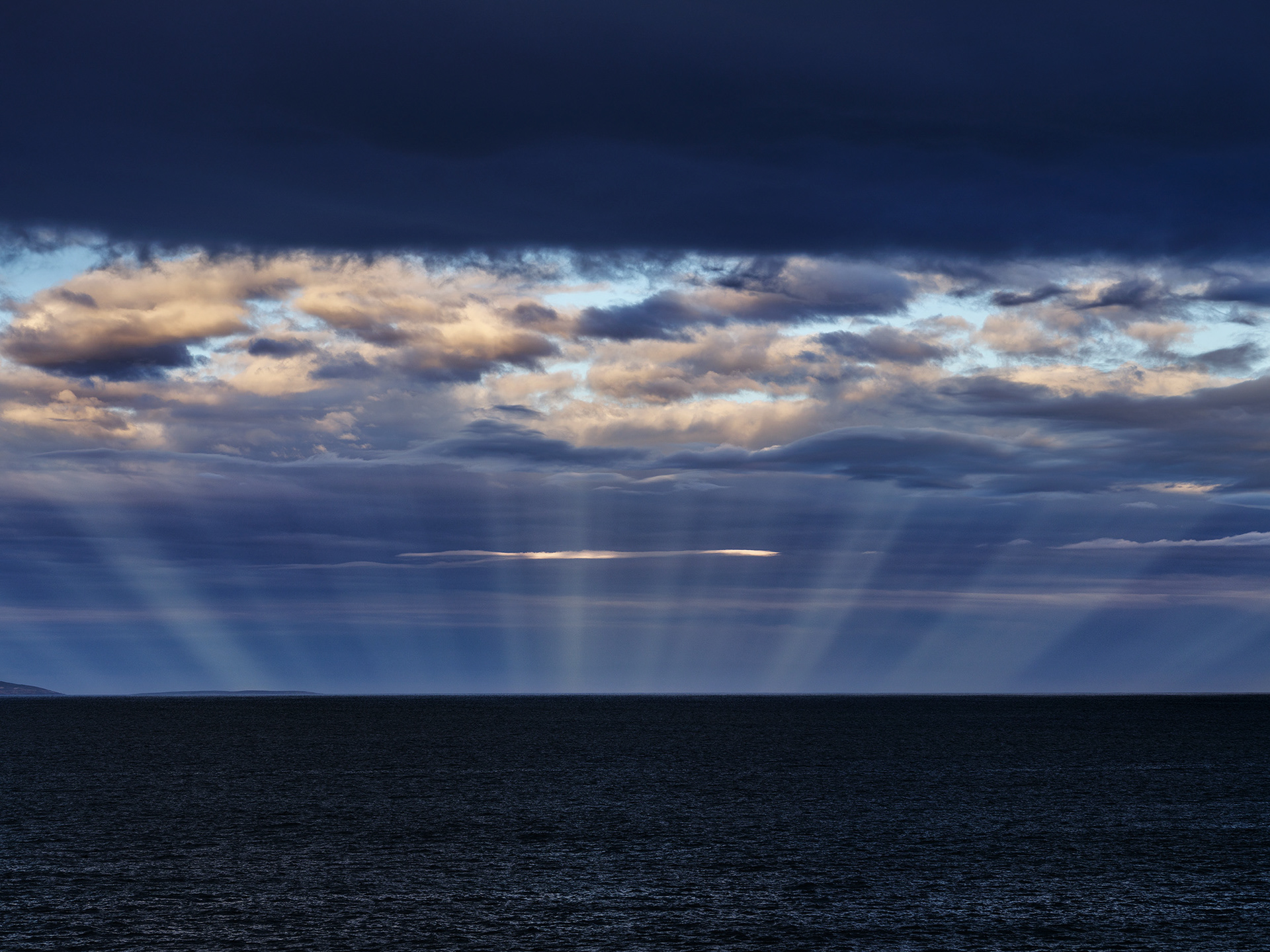 Anticrepuscular rays create a stunning scene across Seaford Bay