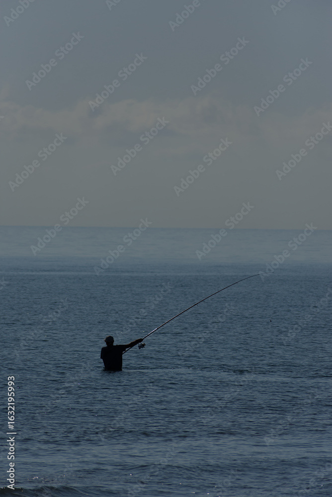 Fisherman with a long fishing rod