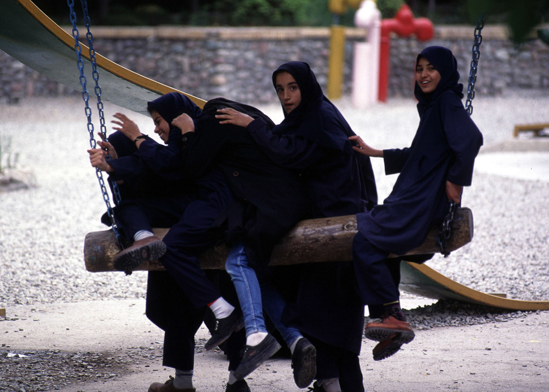 TEHRAN, IRAN -- SCHOOL GIRLS PLAY ON THE SWING IN A NORTH TEHRAN PARK AFTER SCHOOL.  PHOTOGRAPH BY BARRY IVERSON