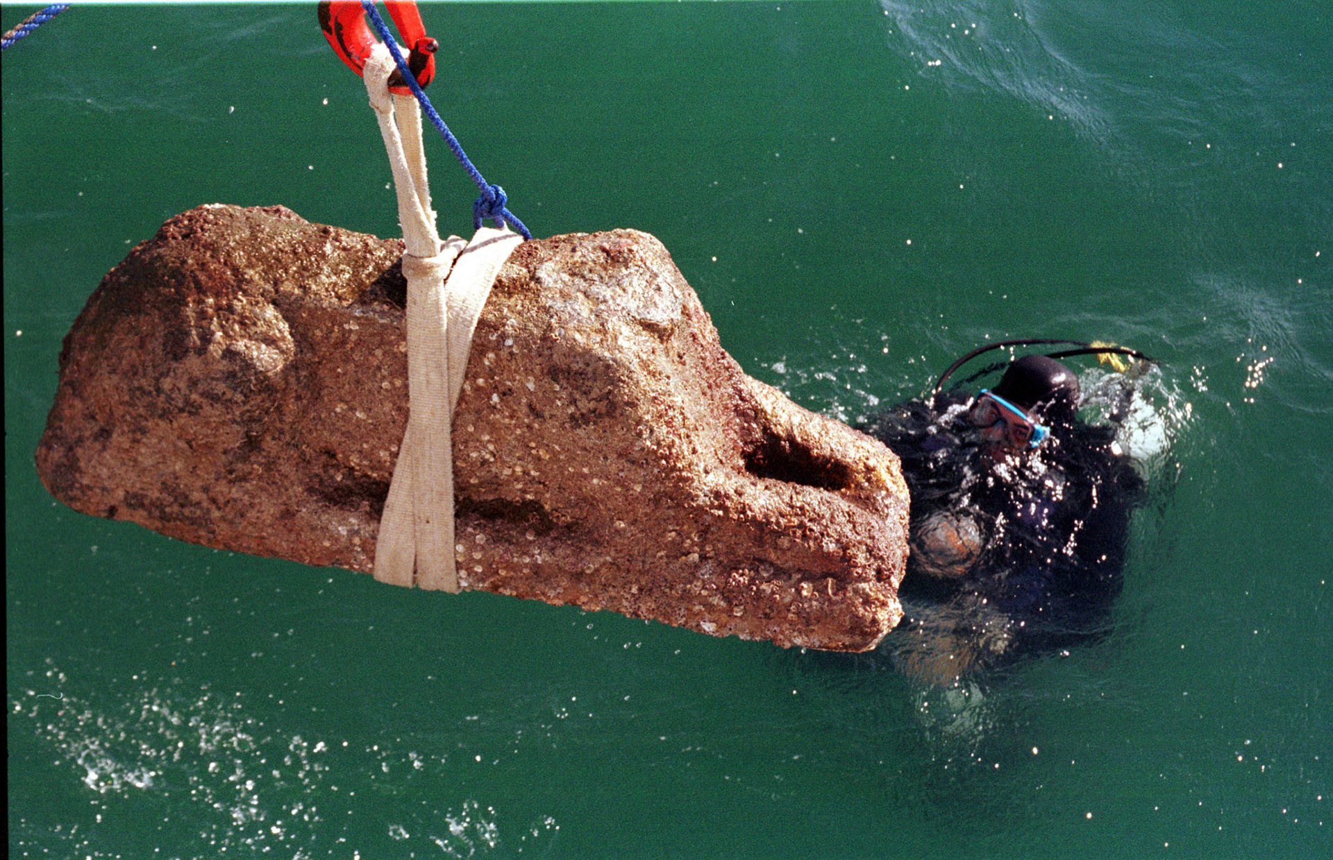 ABU KIR, EGYPT -- 27 MAY 2002 -- A DELIGHTFUL SEA ENCRUSTED GRANITE HEADLESS SPHINX IS BROUGHT UP FROM THE BOTTOM OF THE SEA OFF ALEXANDRIA  BY DIVERS WORKING FOR FRANK GODDIO'S MARINE ARCHAEOLOGY MISSION THAT IS EXPLORING THE ANCIENT EGYPTIAN CITY OF HERACLEION.   THE HEAD WAS FOUND LYING CLOSEBY, AND WAS LATER RAISED TO THE SURFACE TO BE ONCE AGAIN UNITED WITH THE BODY ON THE DECK OF THE RESEARCH VESSEL.PHOTO BY BARRY IVERSON