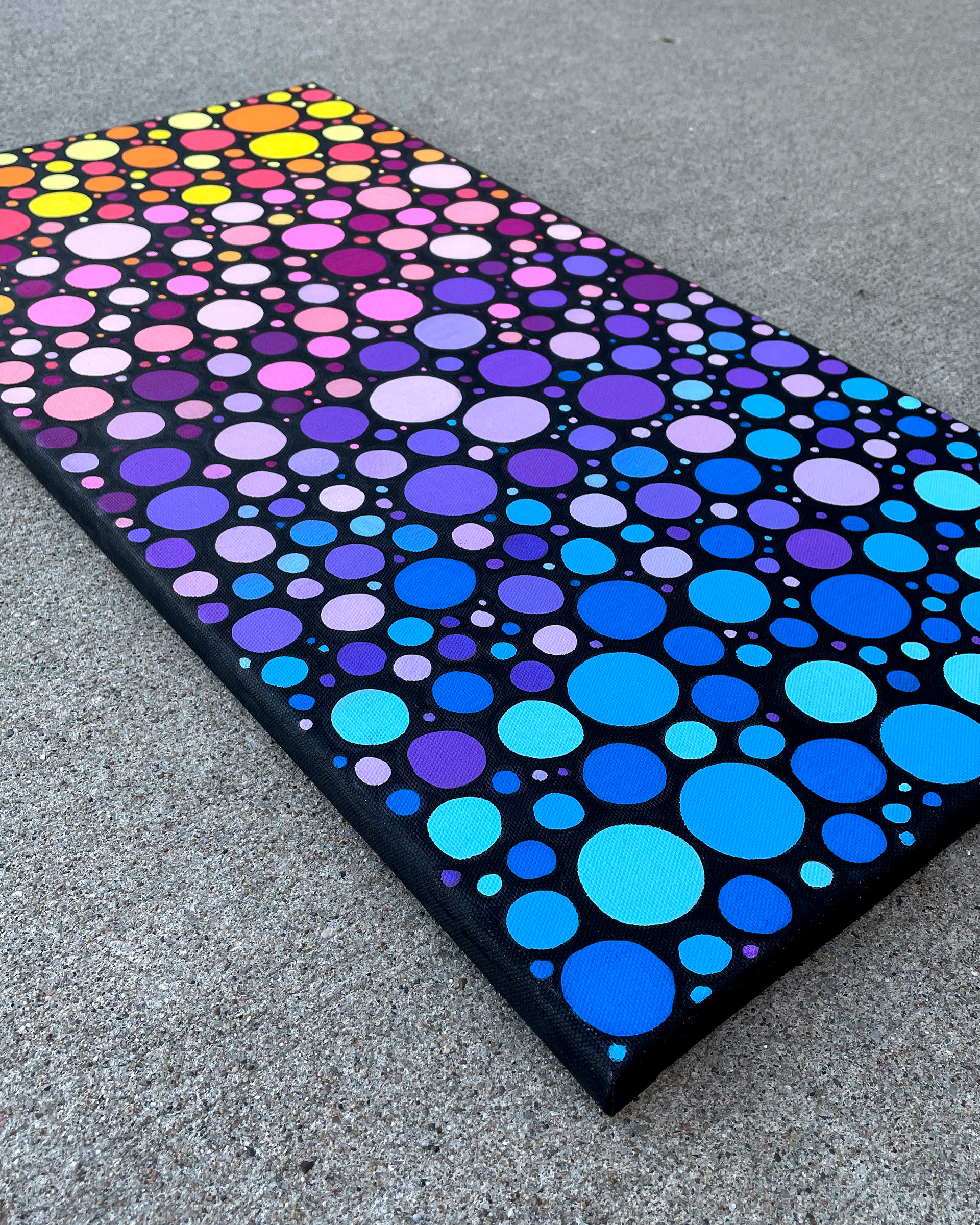 Side of "Sunrise Circles no. 1," Acrylic on canvas. 12 x 24 x 0.5 inches. 2022.