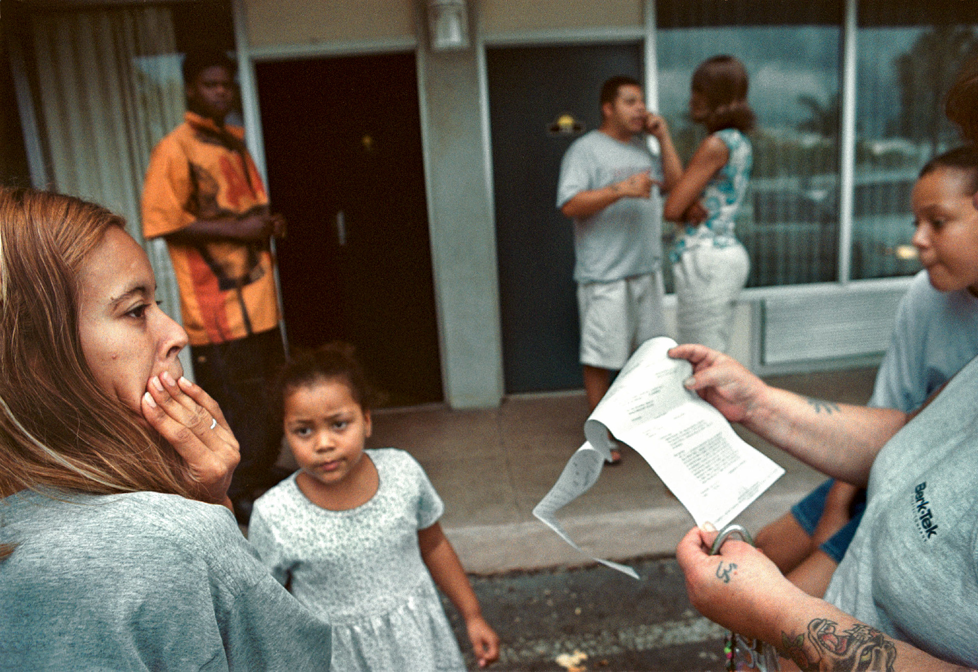Residents read eviction notice after refusing to pay rent in crumbling apartment building.