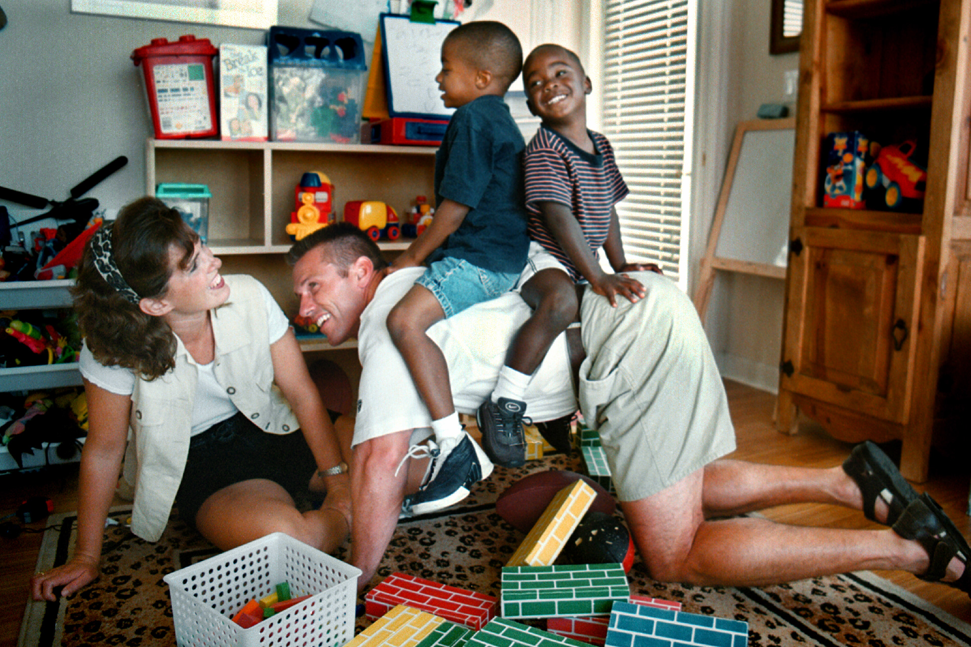 Michelle and Rick Spielman play with adopted sons, Ronnie, 5, and J.D., 3, in racially diverse community.