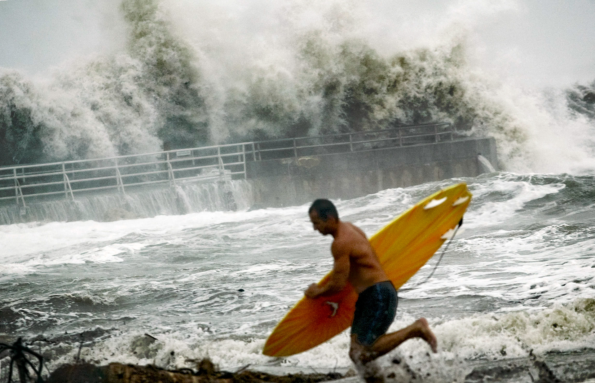 Surf pounds Jupiter Inlet as surfer rushes the catch last wave ahead of Hurricane Jeanne. 