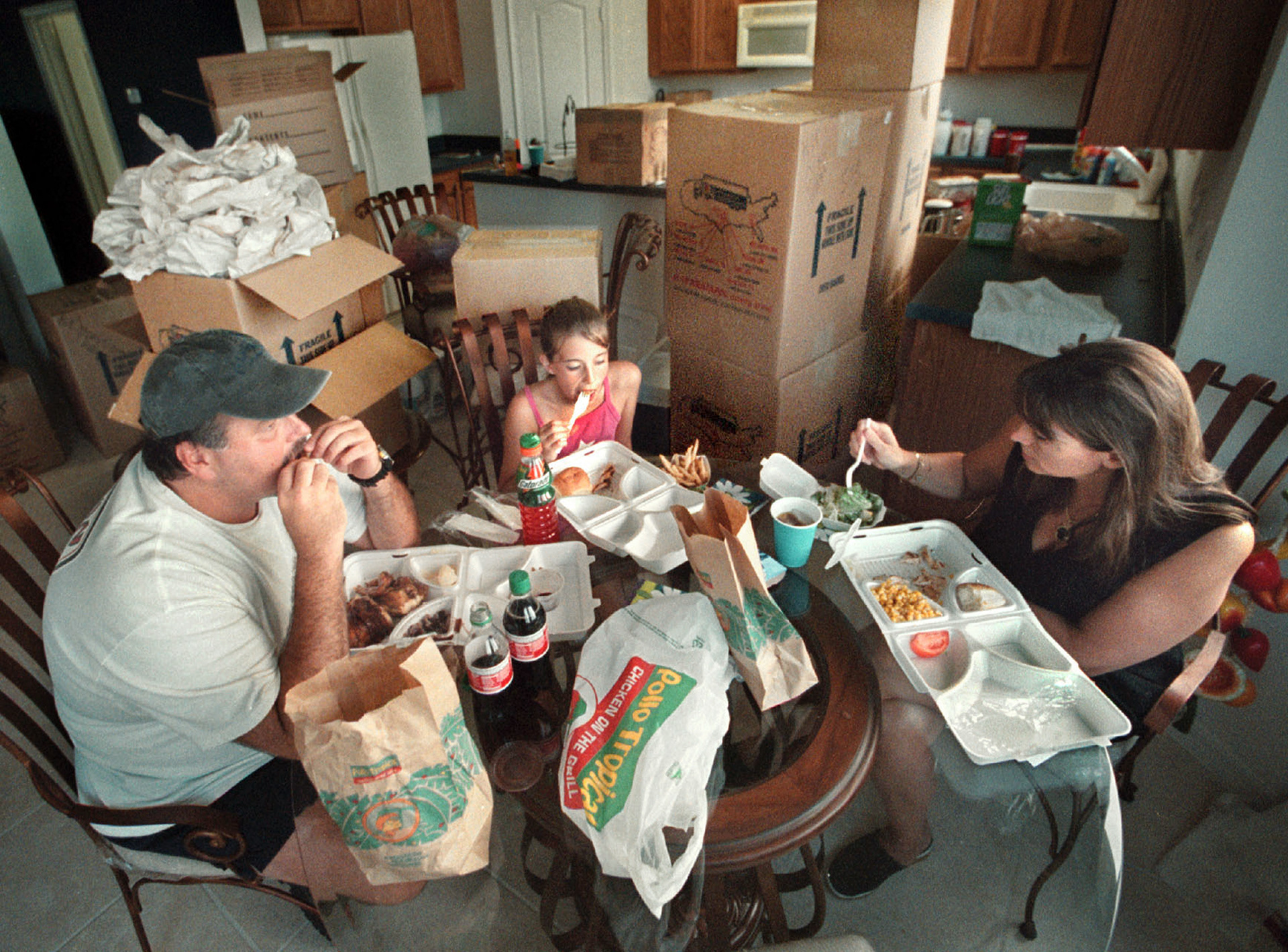 Hawkins family take break from unpacking for first family meal in new home. 