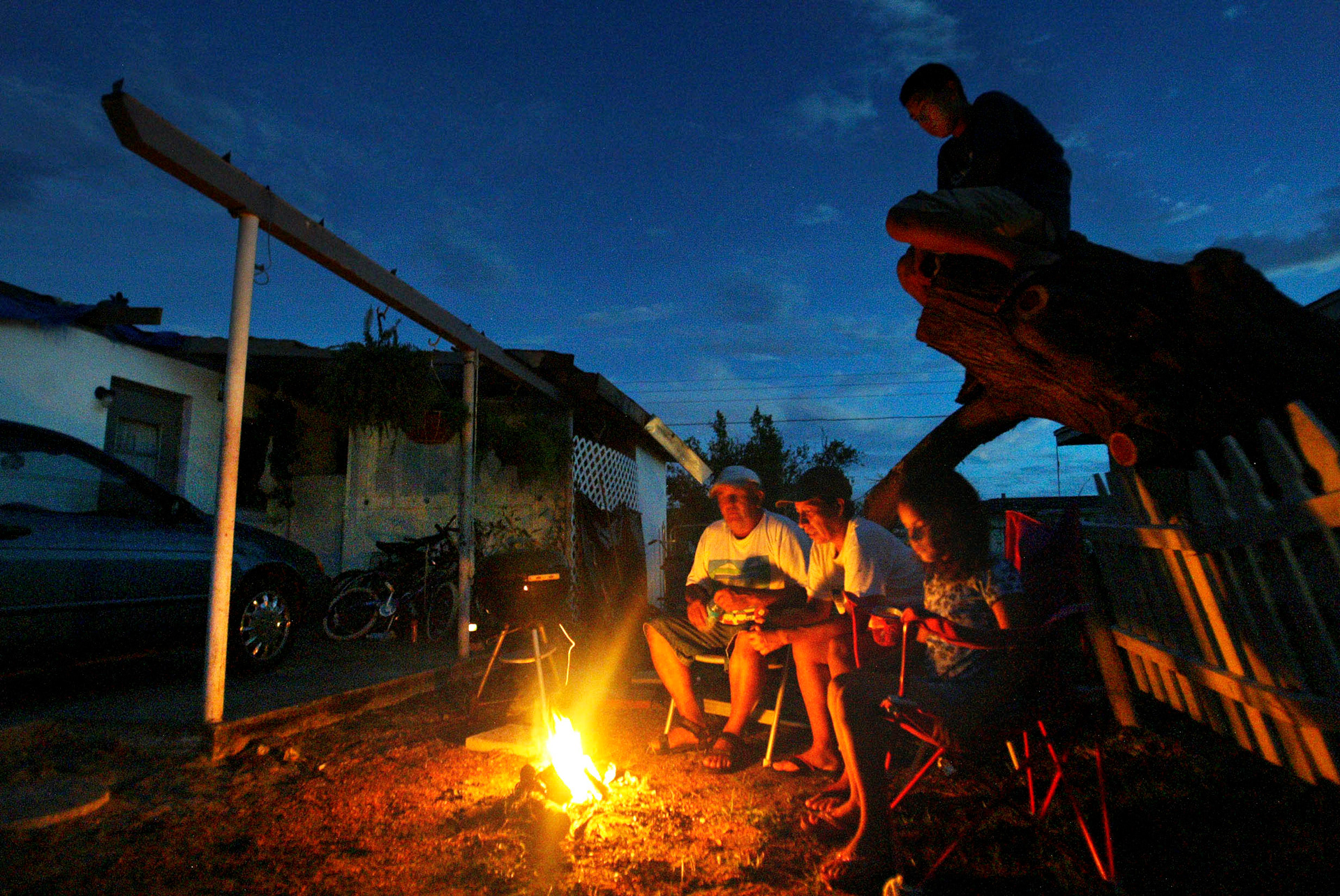 The Bolanos family spend their evenings outside as home is wet and muggy with no roof and electricity.