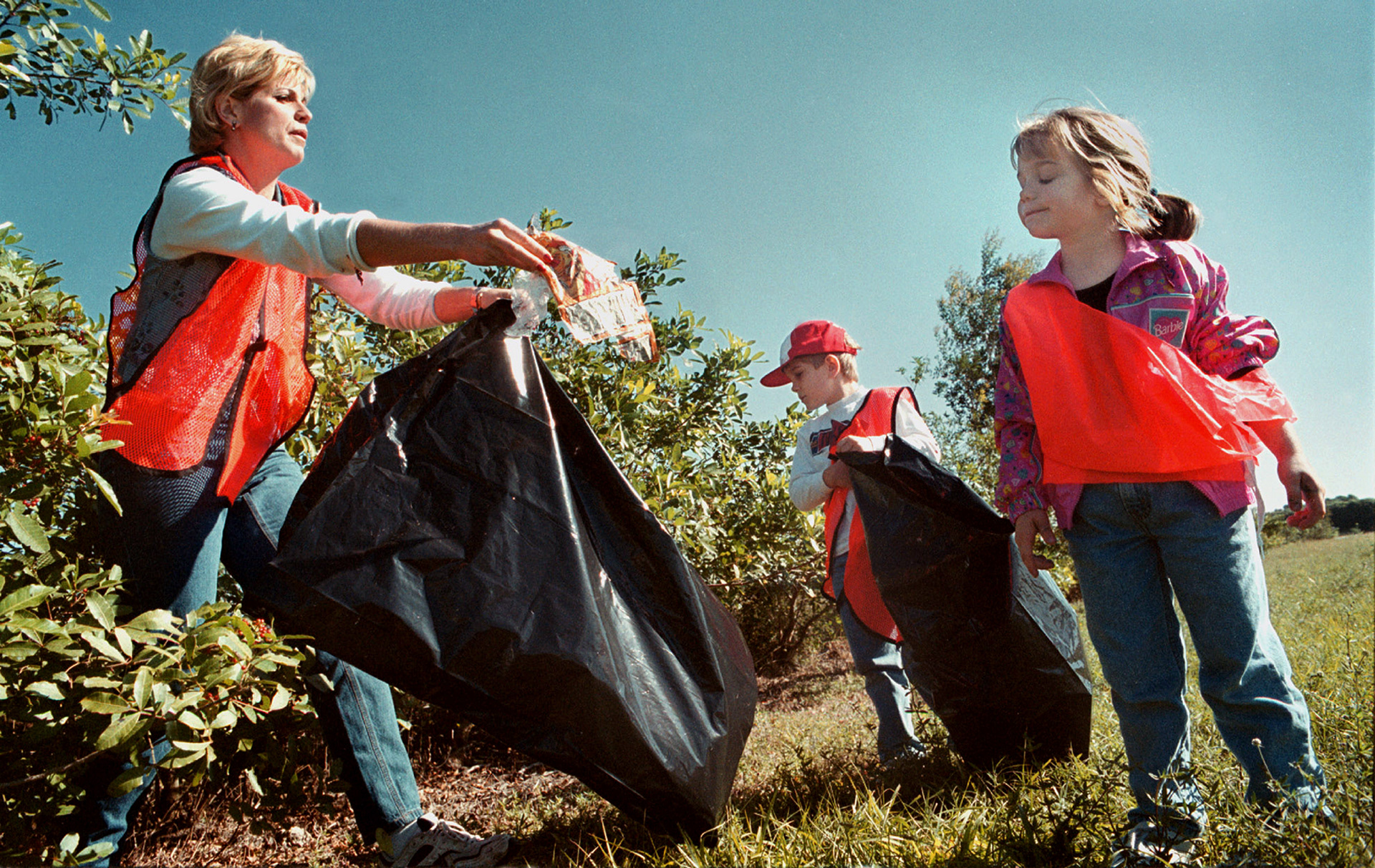 Volunteer Kristi Krueger-Templin encourages daughter Kelsey to participate in community cleanup with brother Troy.