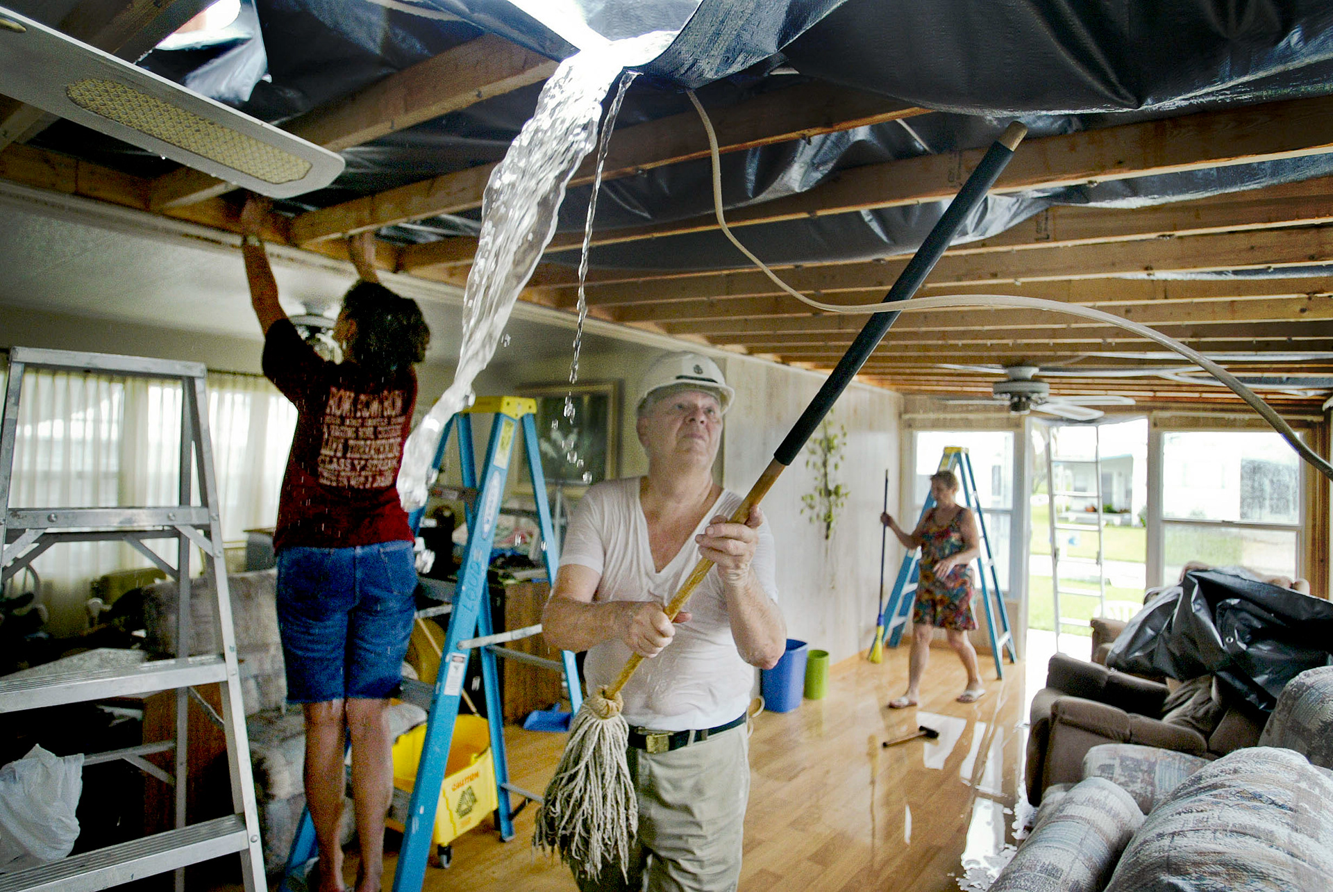 Rain water continues to pour into Janice Loudy’s home which had roof torn off by Hurricane Jeanne.