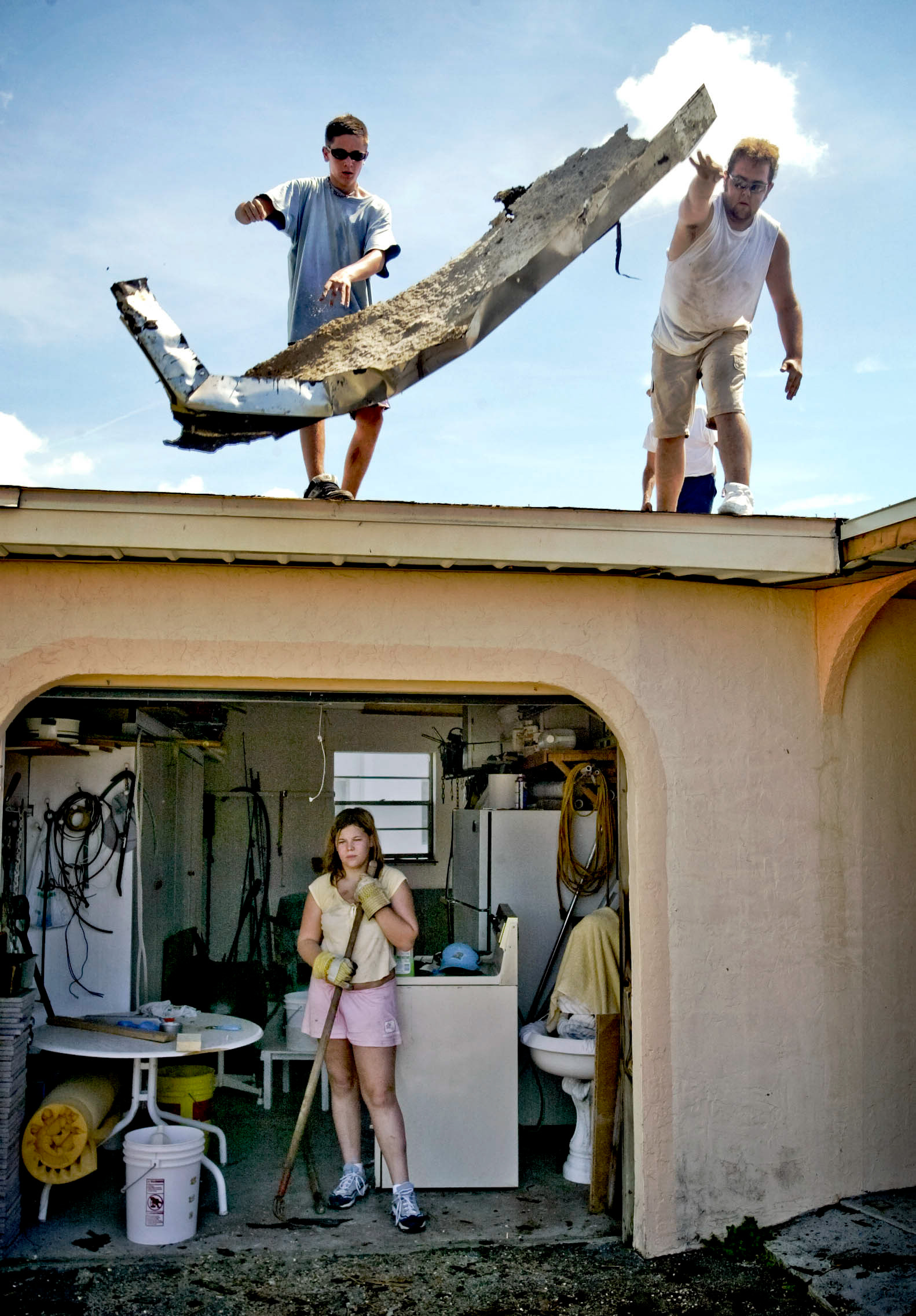Rachel Kocsis takes break in shade as heat swelters during cleanup from Hurricane Charlie.