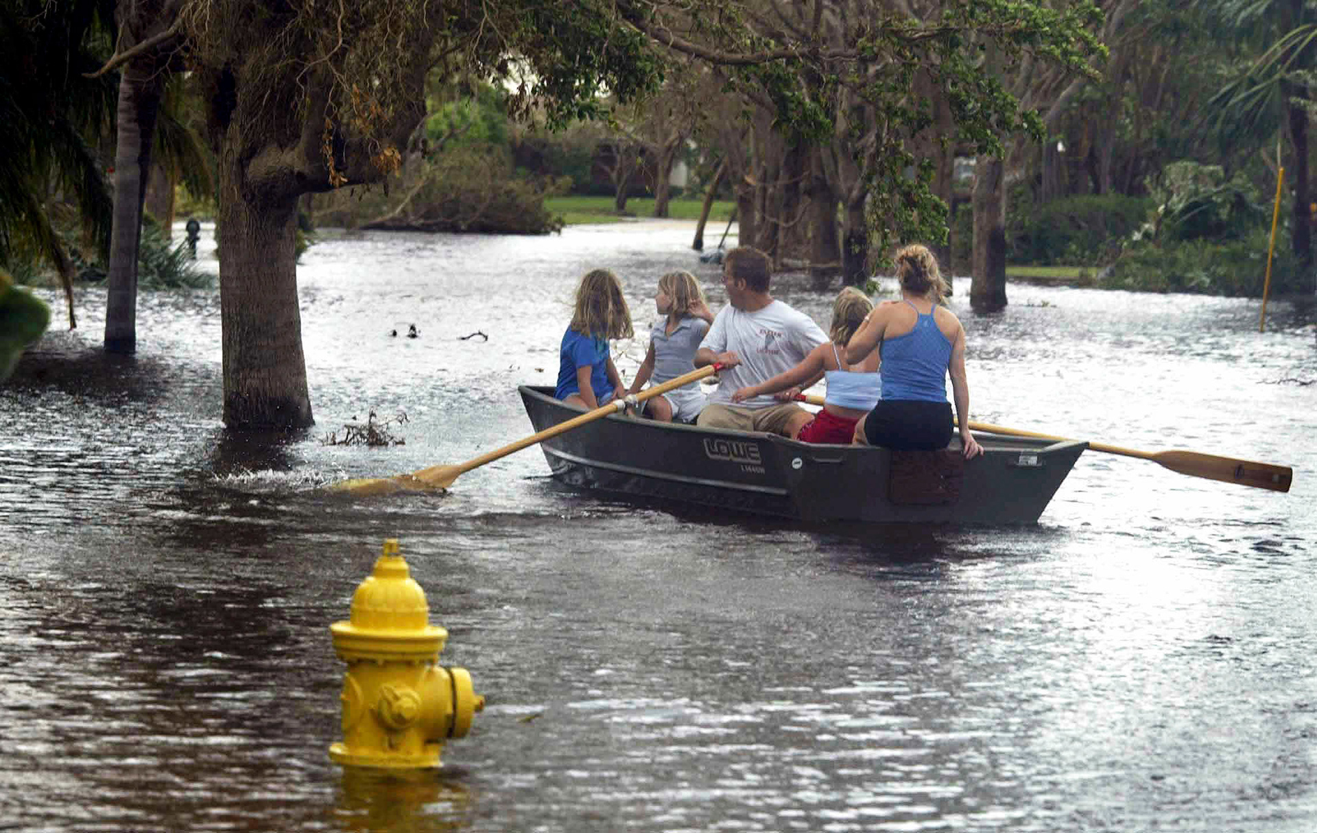 The Young family paddles down the street to check on friends in North Palm Beach.