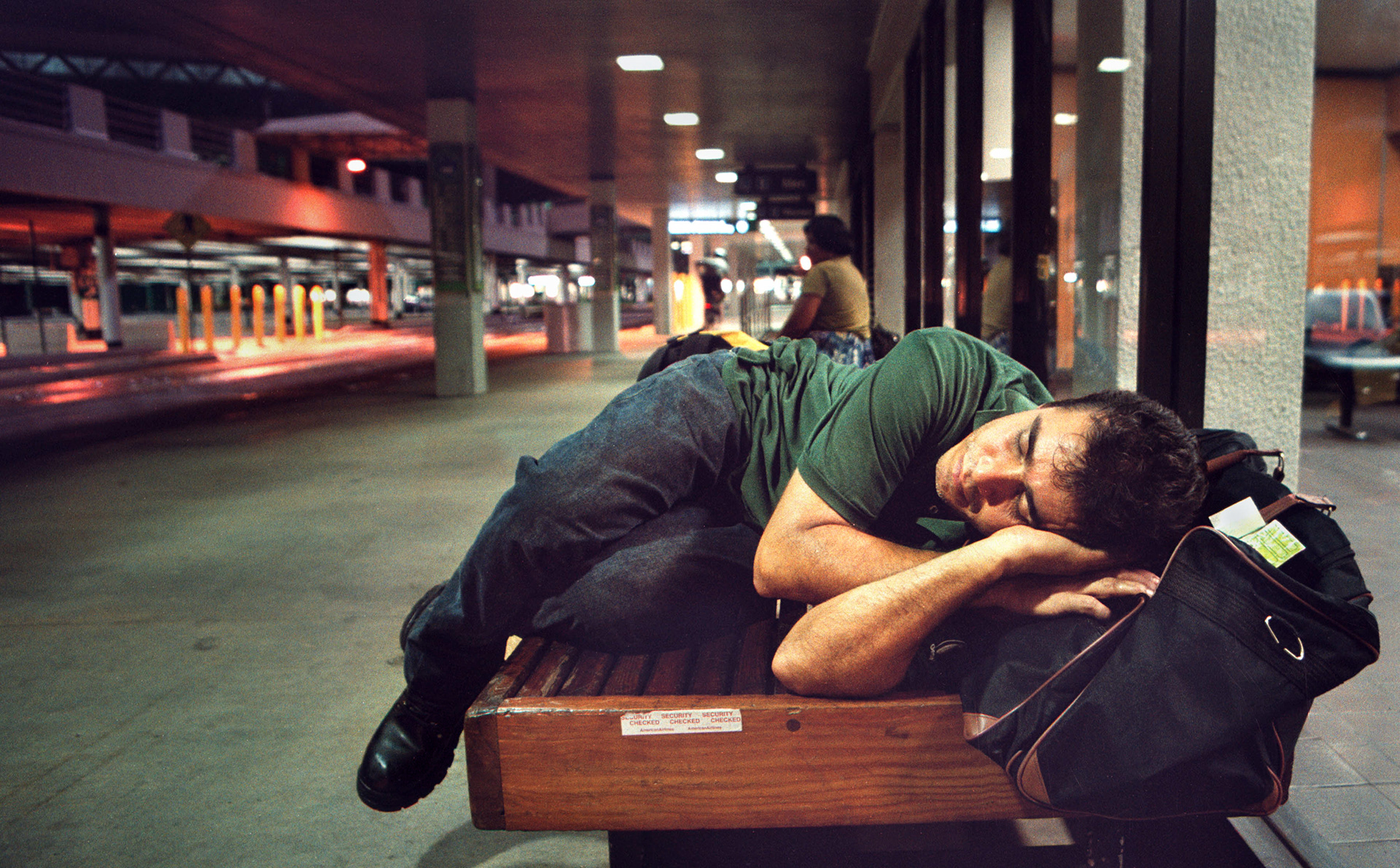 Herrera waits for bus after all-night shift. He falls asleep so deeply that sometimes he misses the bus.