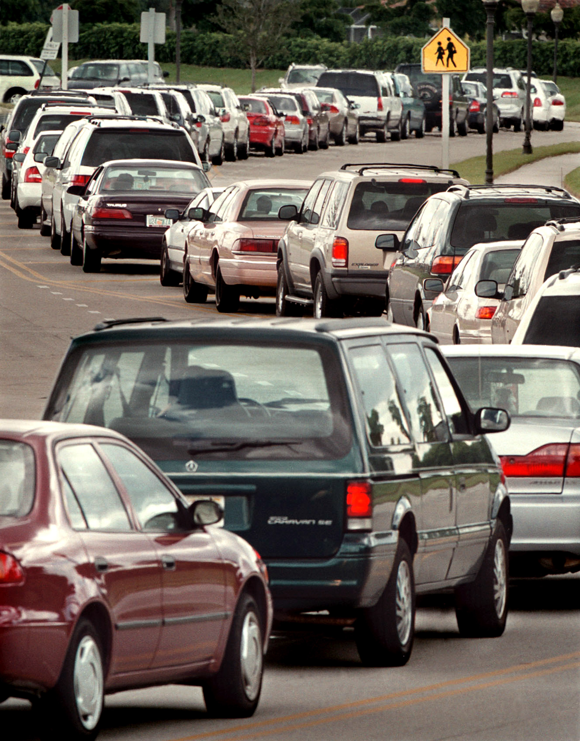 Traffic snakes for 1/2 mile during after-school pickup in overcrowded elementary school.