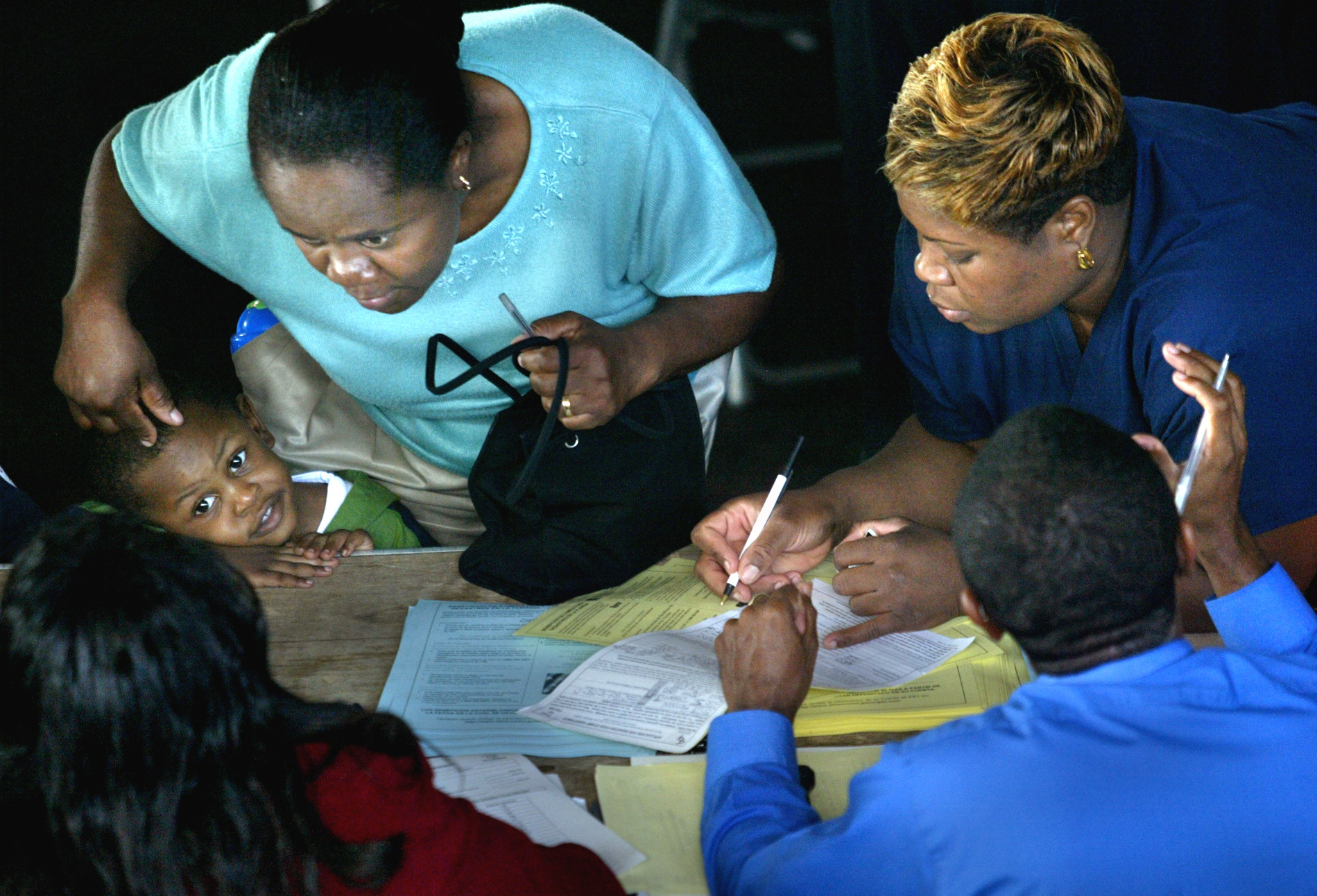 Genese Adescat, with son Roden, 2, applies for emergency assistance from  Florida Disaster Food Stamp program.